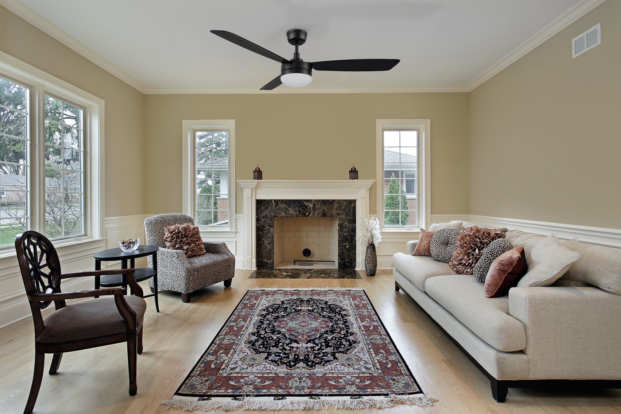 52-inch Sahar 3-blade ceiling fan in black, mounted in a modern living room with a downrod. With the retro classic Persian carpet, elegant fireplace design, beige couch, and other features of the furniture, black modern and retro fan combined, making the whole bedroom very Nordic style