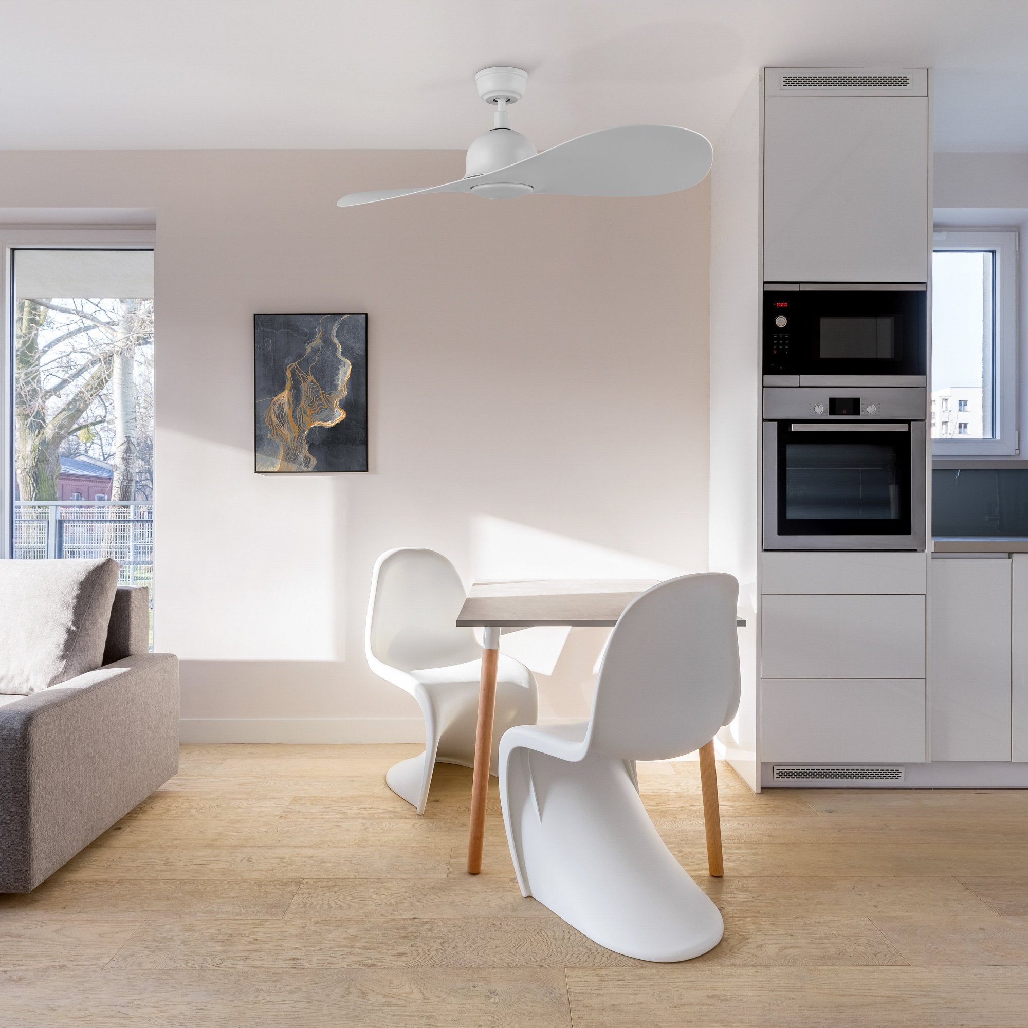Azure modern white ceiling fan with LED light installed in a clean and minimalist dining room, featuring white furniture and wooden flooring.