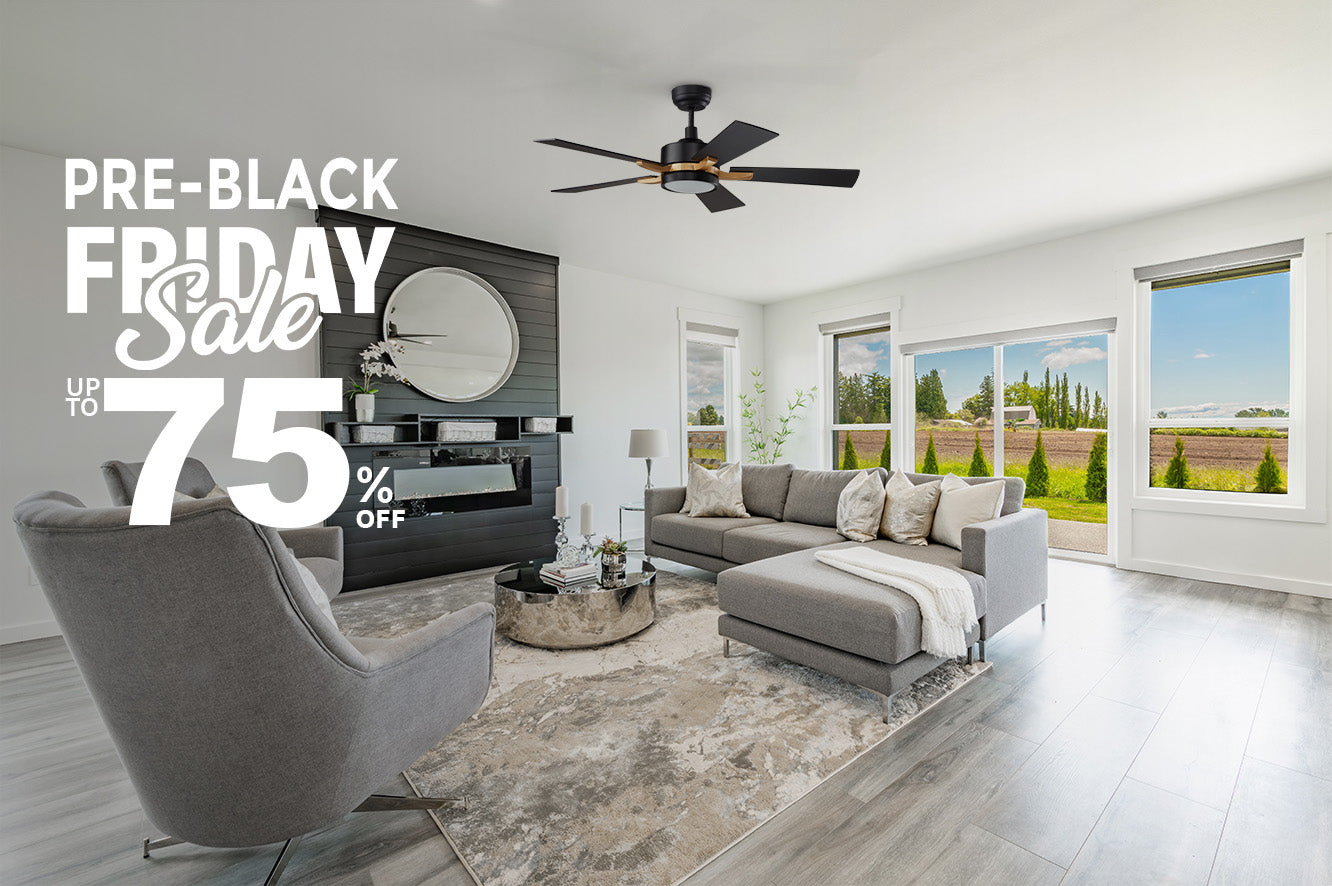 A modern, bright living room featuring 52 inch Apex black and gold smart ceiling fan. The room is decorated with a large, gray sectional sofa, a matching armchair, a round silver coffee table, and a rug. A black fireplace and a large round mirror are on one wall, while large windows offer a view of an open field. The image is overlaid with text promoting a "PRE-BLACK FRIDAY Sale" with "UP TO 75% OFF."