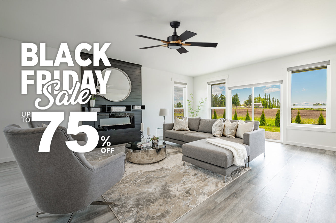 A modern, bright living room featuring 52 inch Apex black and gold smart ceiling fan. The room is decorated with a large, gray sectional sofa, a matching armchair, a round silver coffee table, and a rug. A black fireplace and a large round mirror are on one wall, while large windows offer a view of an open field. The image is overlaid with text promoting a "PRE-BLACK FRIDAY Sale" with "UP TO 75% OFF."