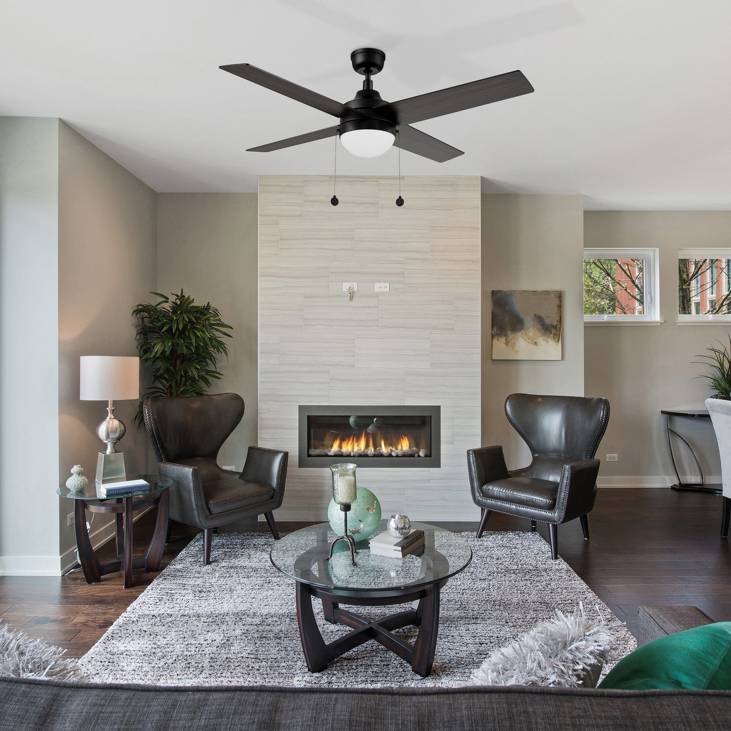 52-inch dowrnrod mount black ceiling fan with LED light, matching to black leather sofa, the black wooden stand glass coffee table, and the cool decorative fireplace, the whole bedroom is very modern.