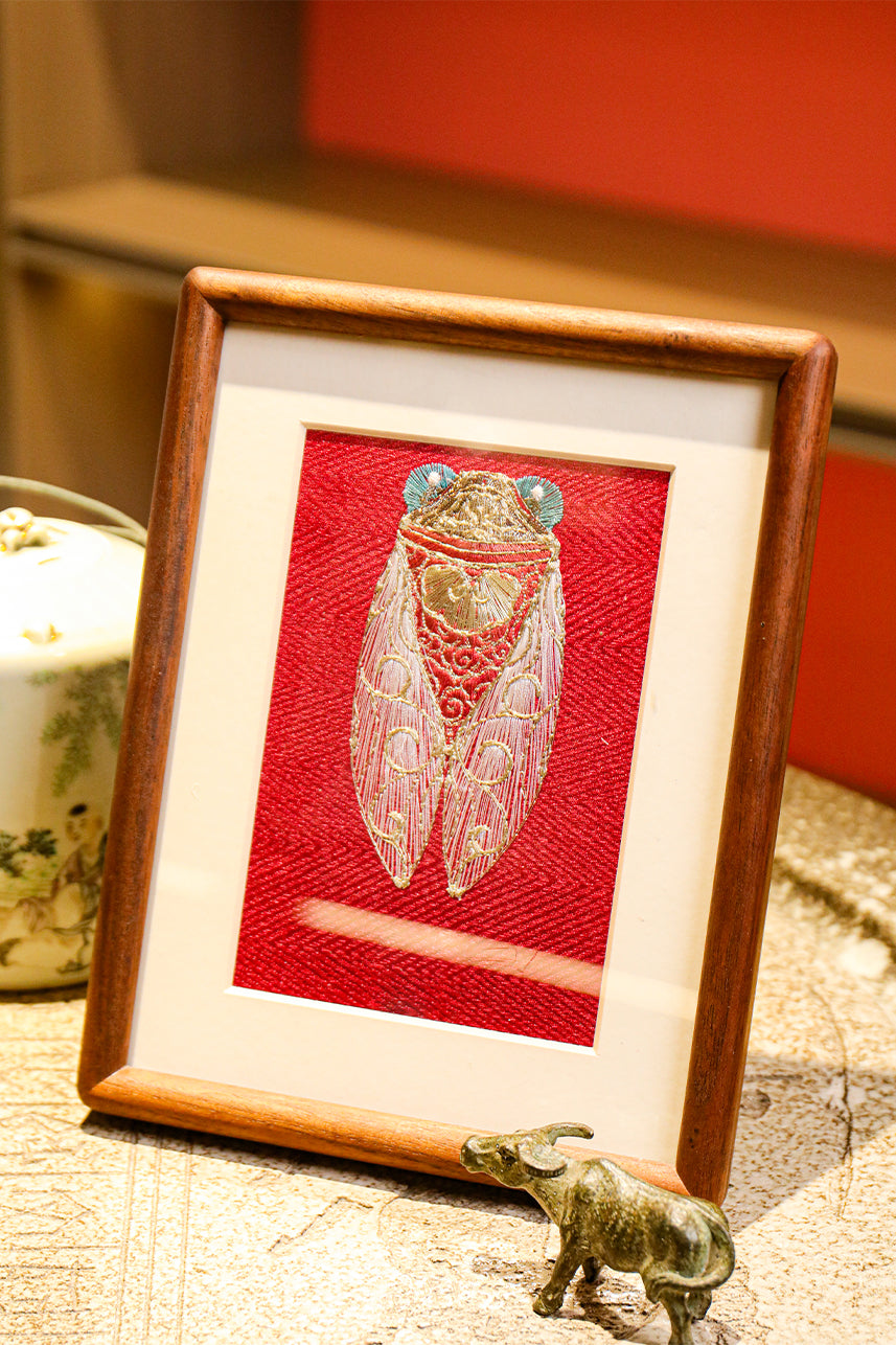 Embroidered works of art with golden cicadas, accompanied by bronze cows and white teacups with children on them, are quietly placed on bluestone countertops.