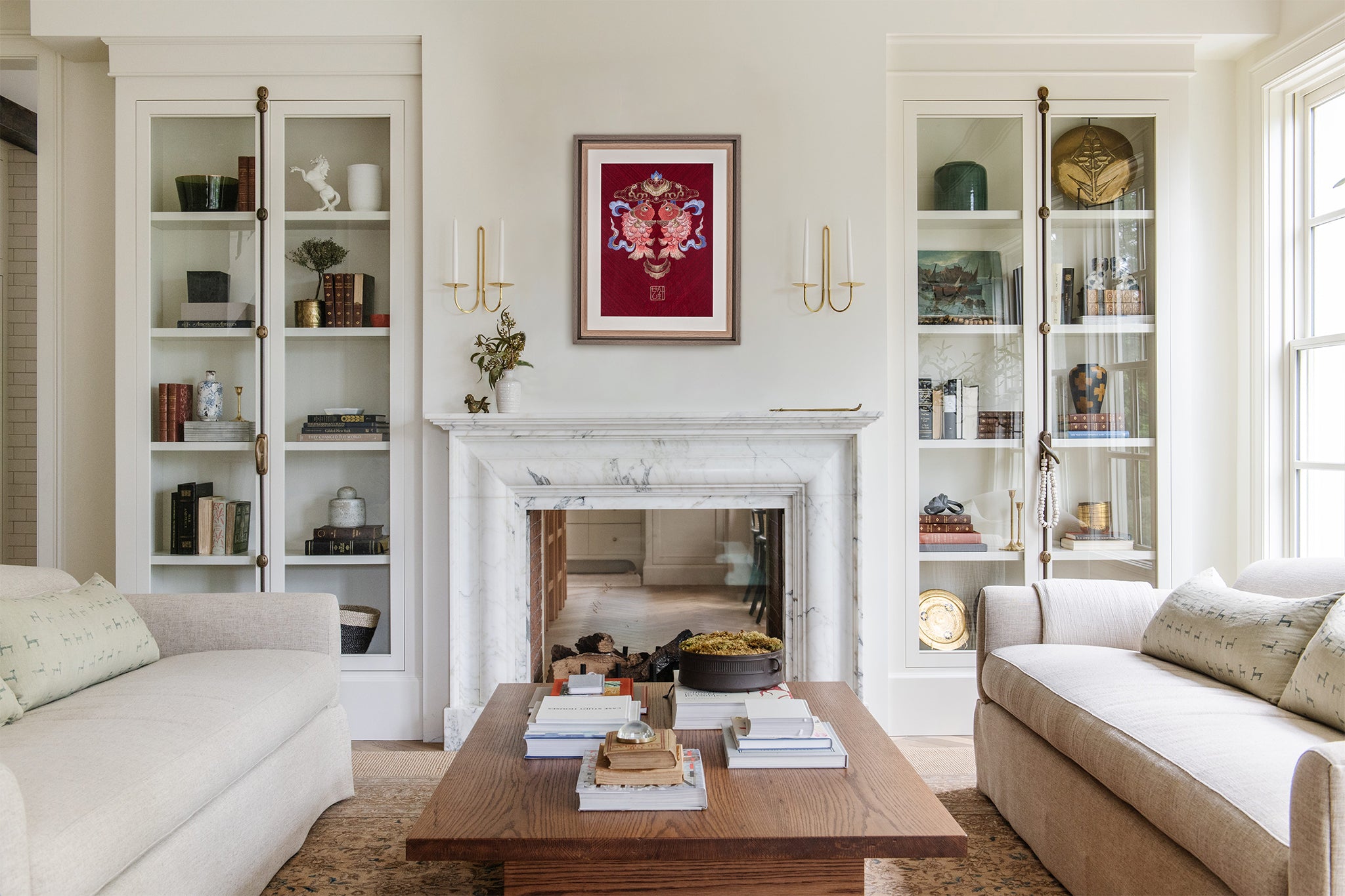 In the middle of a Nordic simple style living room, hanging a red background of double koi embroidery art.