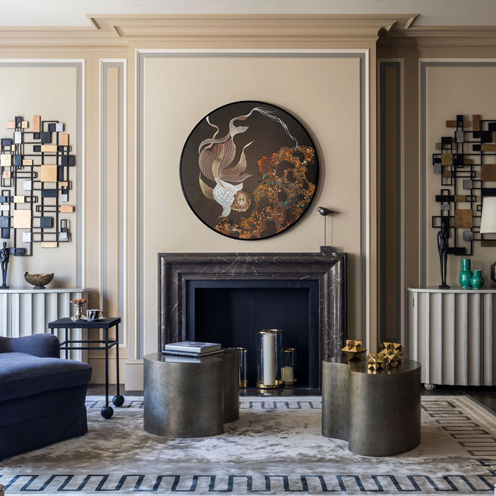An artwork embroidered with koi fish hangs above the fireplace in the modern living room.