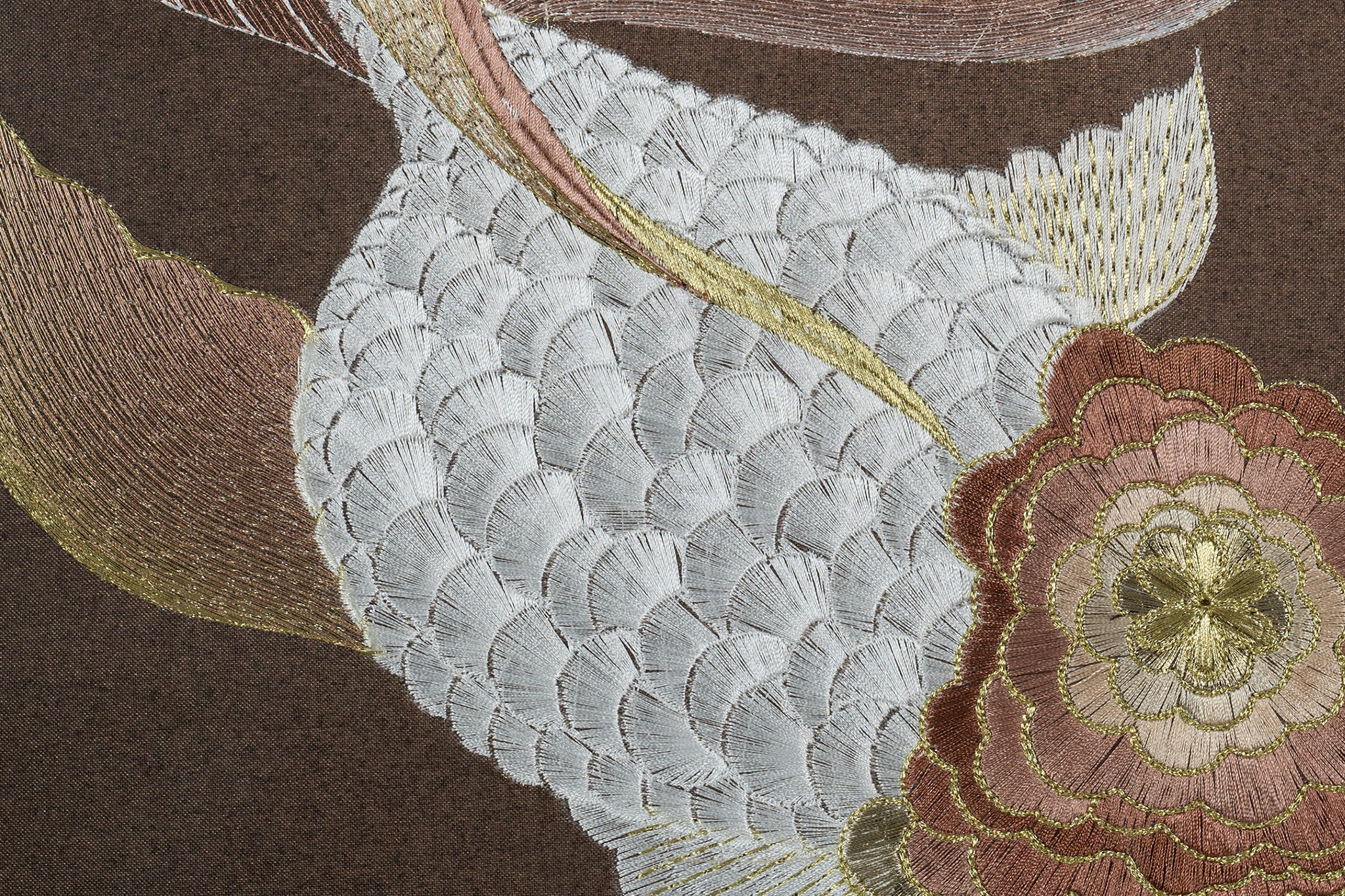 An embroidered work of art features a carp with white scales and a yellow backbone.