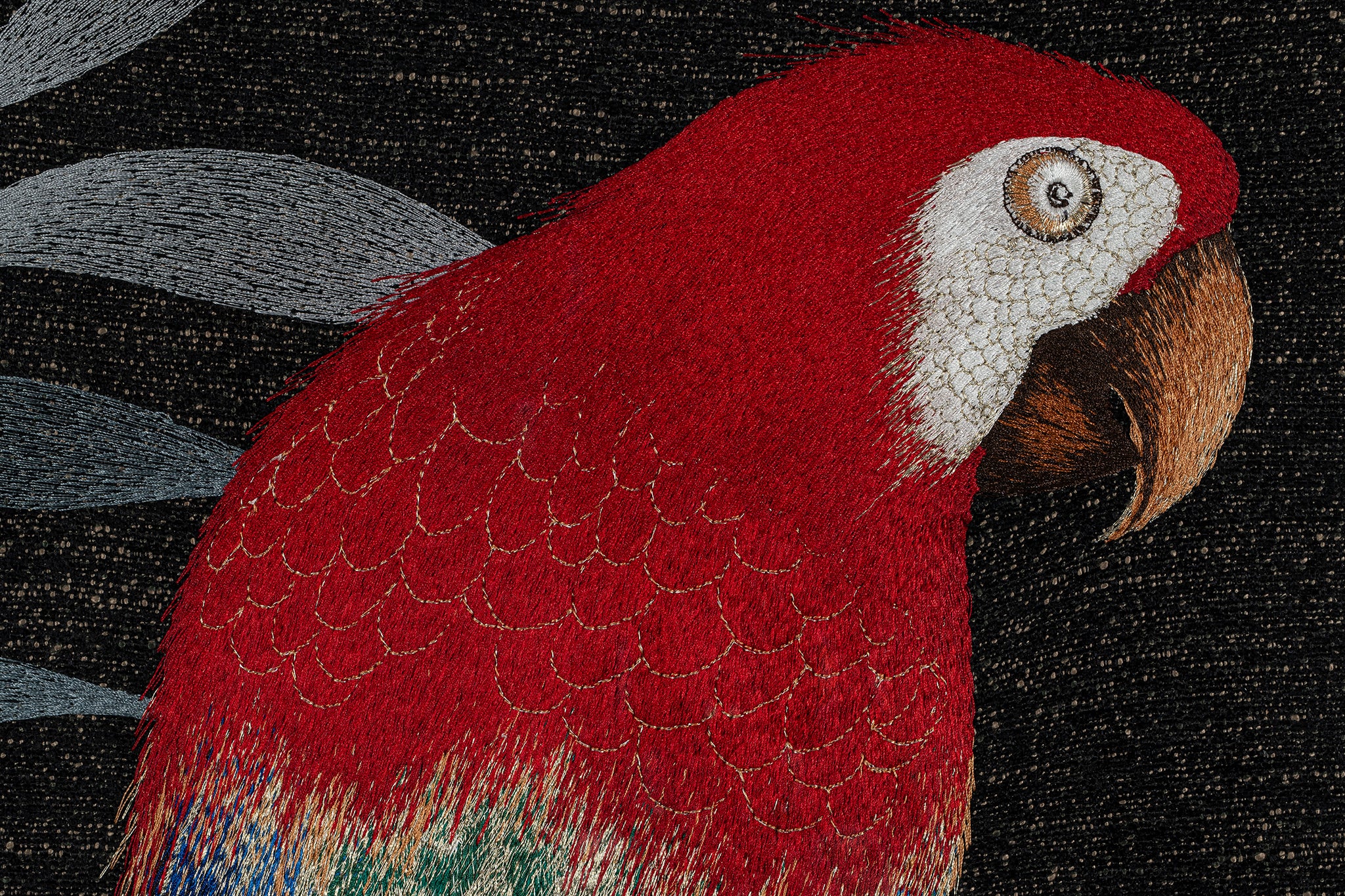 Embroidery silk threads detail of a parrot's upper body.