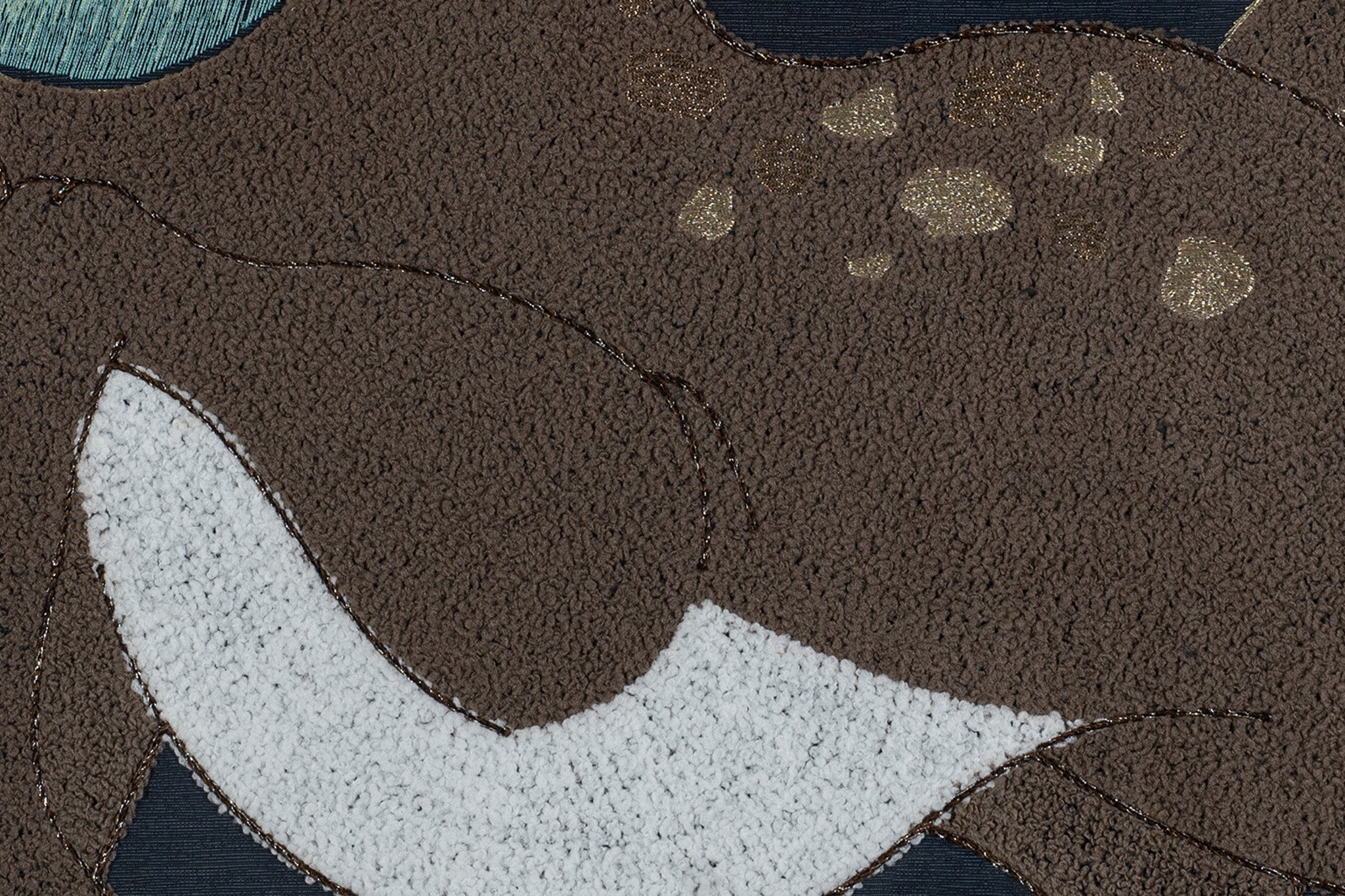 An embroidery artwork showcasing the intricate details of the deer's lower body and belly.