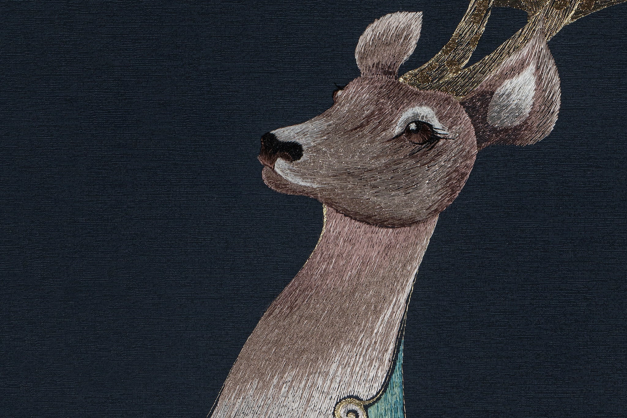 An embroidery artwork showcasing the intricate details of a deer's facial features and head.