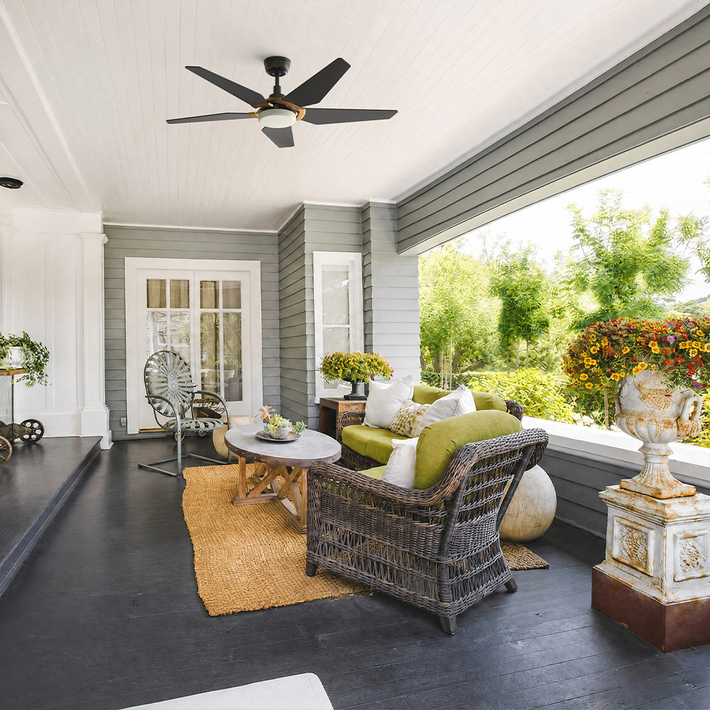 Smafan Voyager 52 inch modern matte black 5 blade outdoor ceiling fan with light installed on a covered porch with wicker patio furniture.