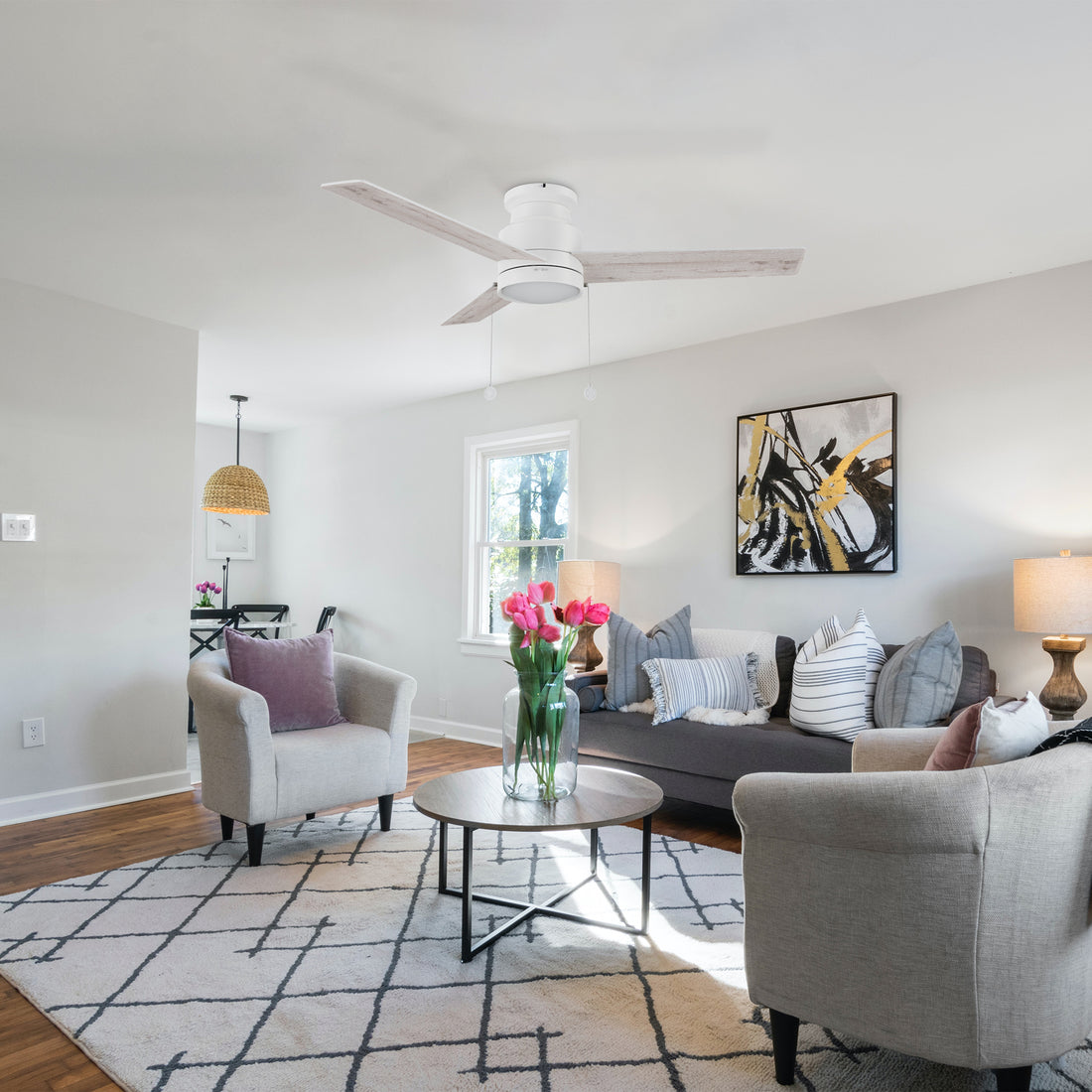 White ceiling fan with flush mounting design, matching to light grey sofa, dark wood grain coffee table, and abstract mural make the whole living room full of modern feeling.