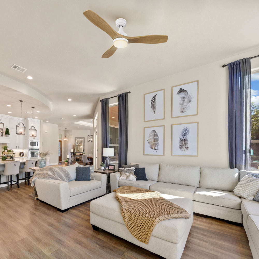 Scandinavian living room with white sofa, gallery wall, and large windows; minimalist Ultiem 48-inch wood ceiling fan in whtie with LED blends with pale floors and airy decor.