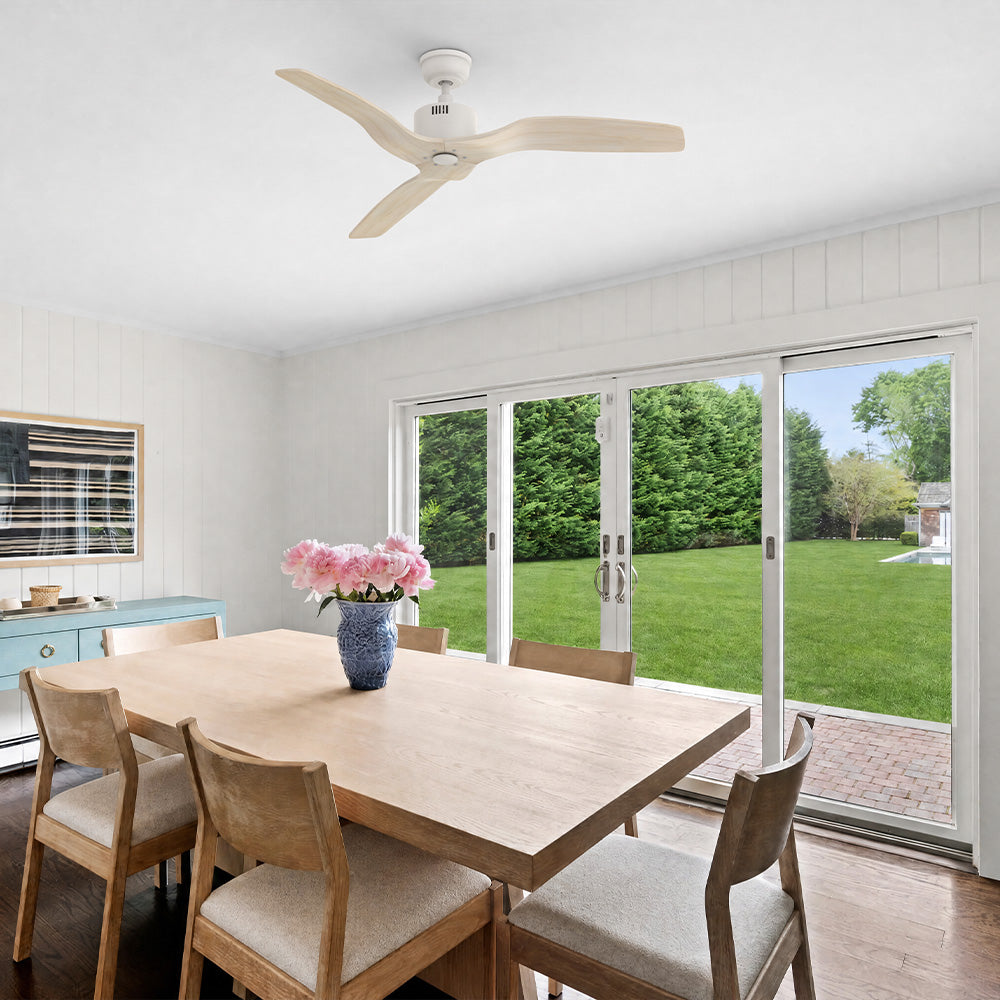 Yarmouth light wood ceiling fan without light installed on a vaulted ceiling in a modern dining room with a large sliding glass door.