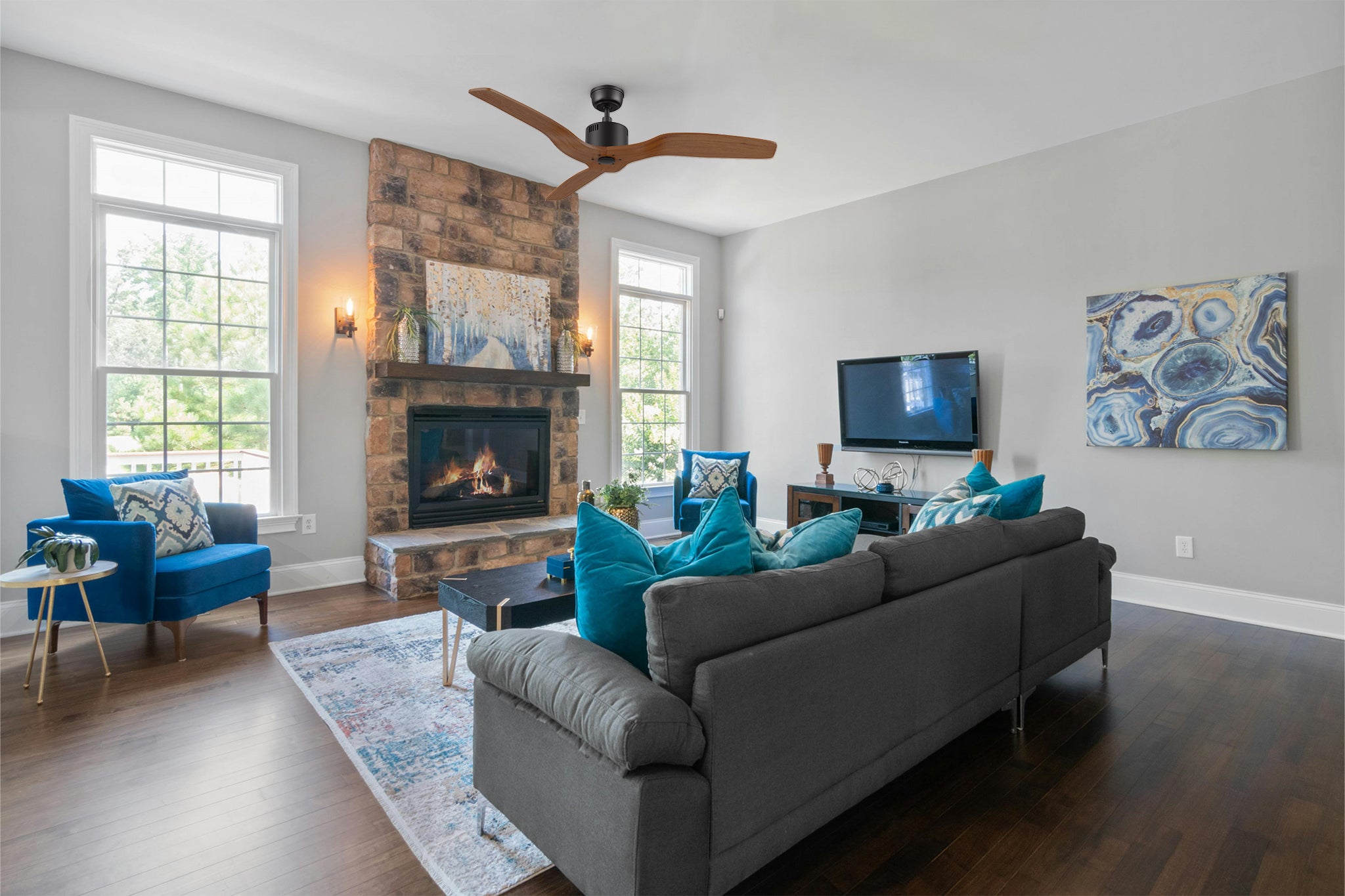 Yarmouth black farmhouse ceiling fan in a contemporary living room with a fireplace, large windows, and elegant furniture arrangements.