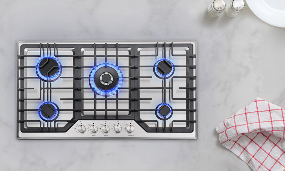 Gas stove with five burners on the white granite countertop.