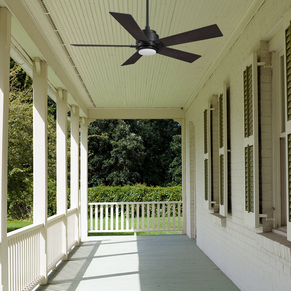 Outdoor patio featuring a 5-blade Aspen 60-inch smart ceiling fan in dark wood gra with an integrated LED light, complementing the bright, white-painted ceiling and providing a modern, functional cooling solution for the porch.