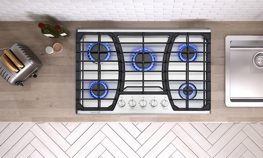 An overhead view with respect to a brushed stainless sheet gas stove on the wood grain kitchen counter.