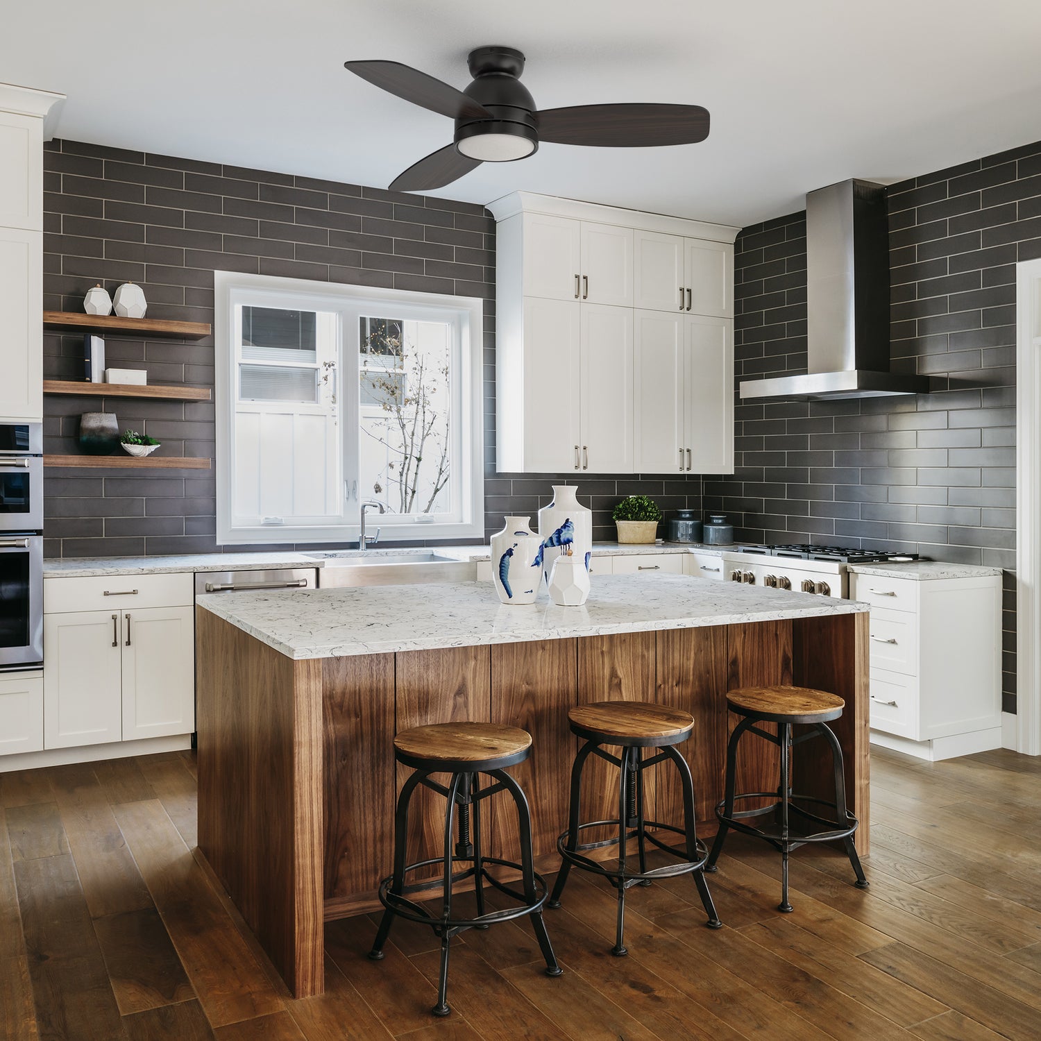 Thibault black ceiling fan with dimmable led light and remote designed in kitchen with modern wood grain elements.