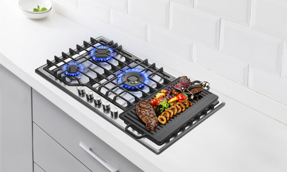 Countertop in white tones. Steak, cherry tomatoes, and squid in a griddle on a gas stove.