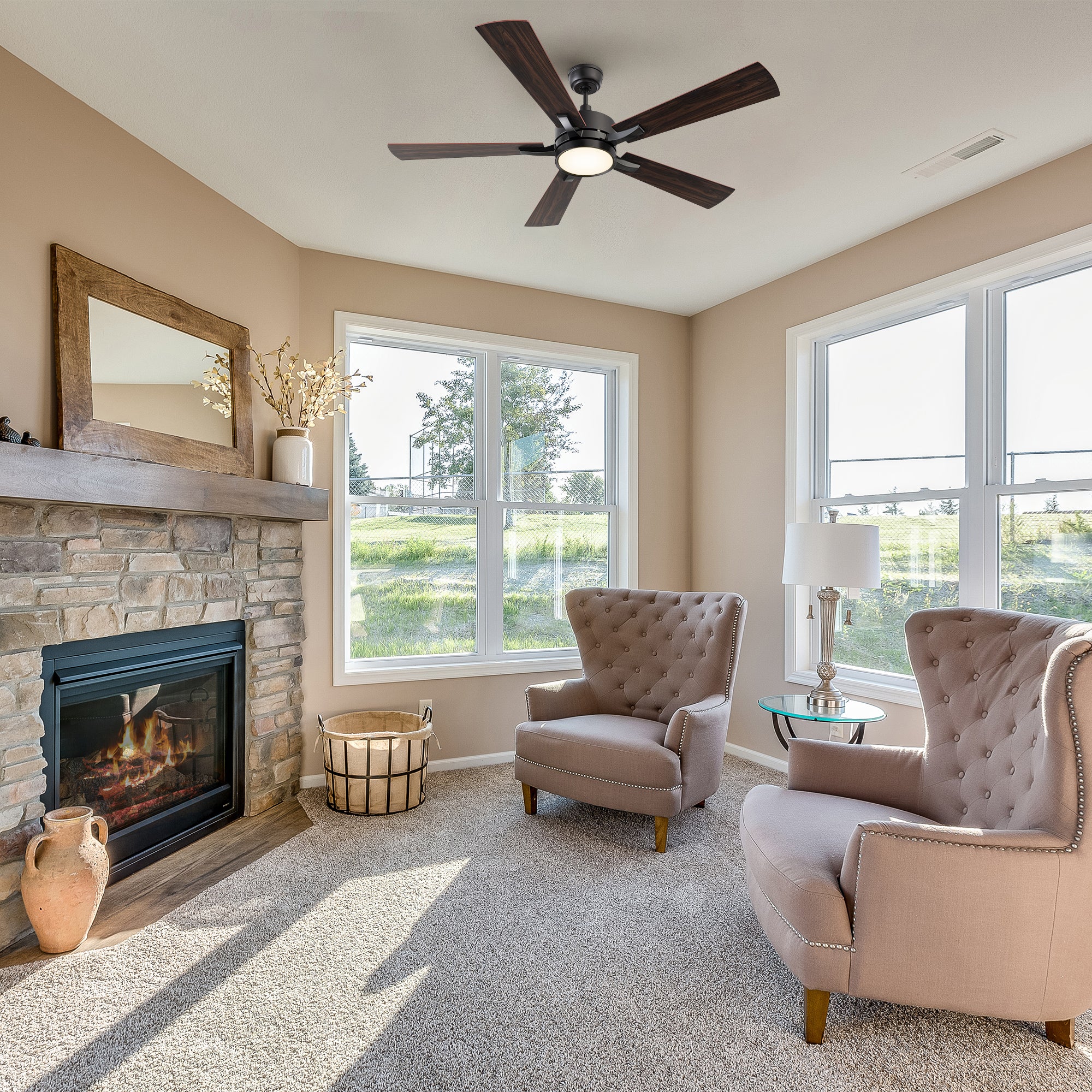 Smafan Apex 56-inch smart ceiling fan with LED light in a cozy living room with beige armchairs, a fireplace, and large windows bringing in natural light.