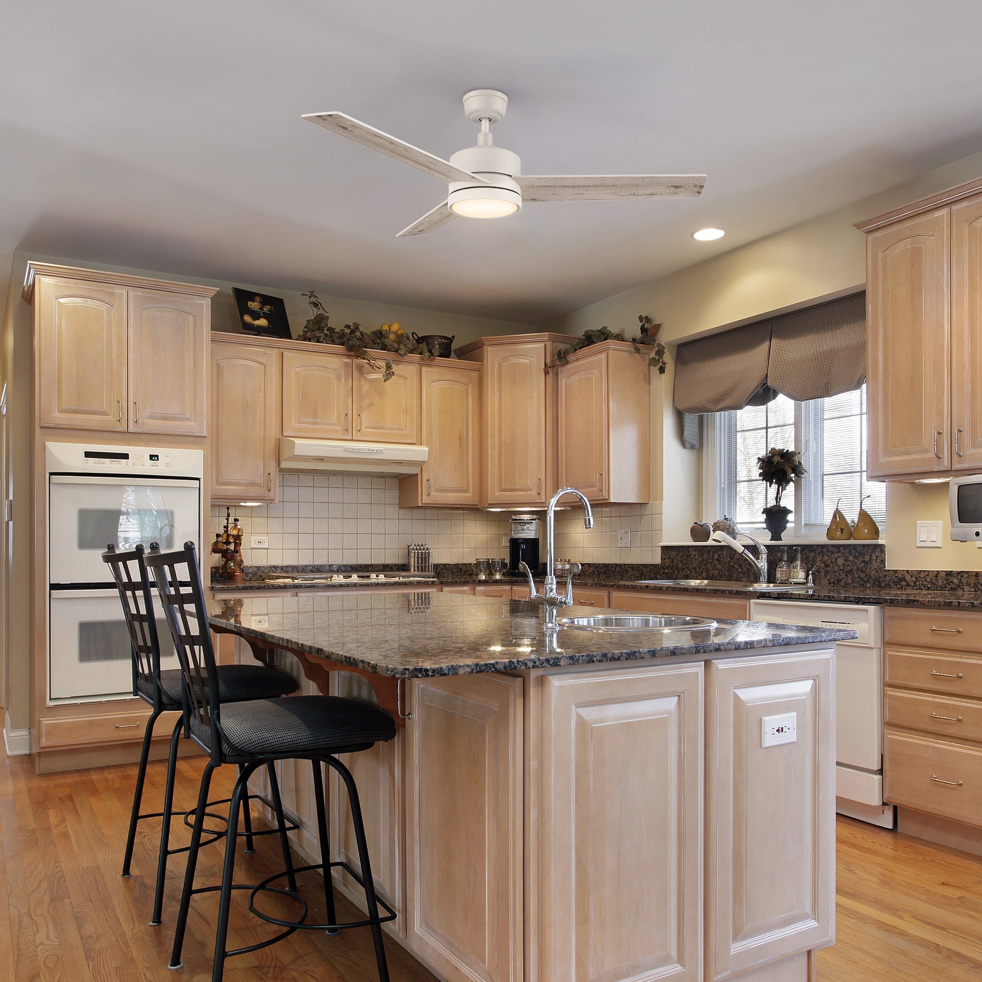 52-inch Louy modern white ceiling fan with LED light and wall switch, installed in a traditional-style kitchen with wood cabinetry, granite countertops, and a central island with bar seating. 