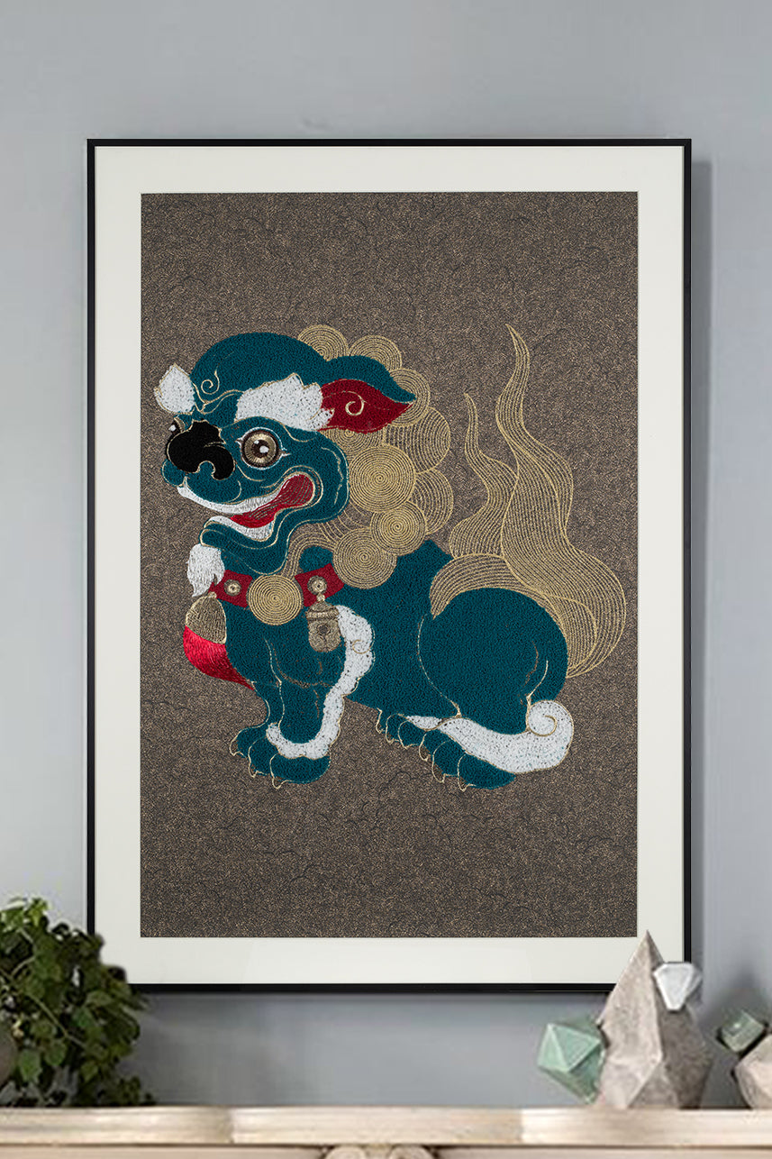 Framed embroidery artwork featuring a lion ball play design with the lion facing right. 