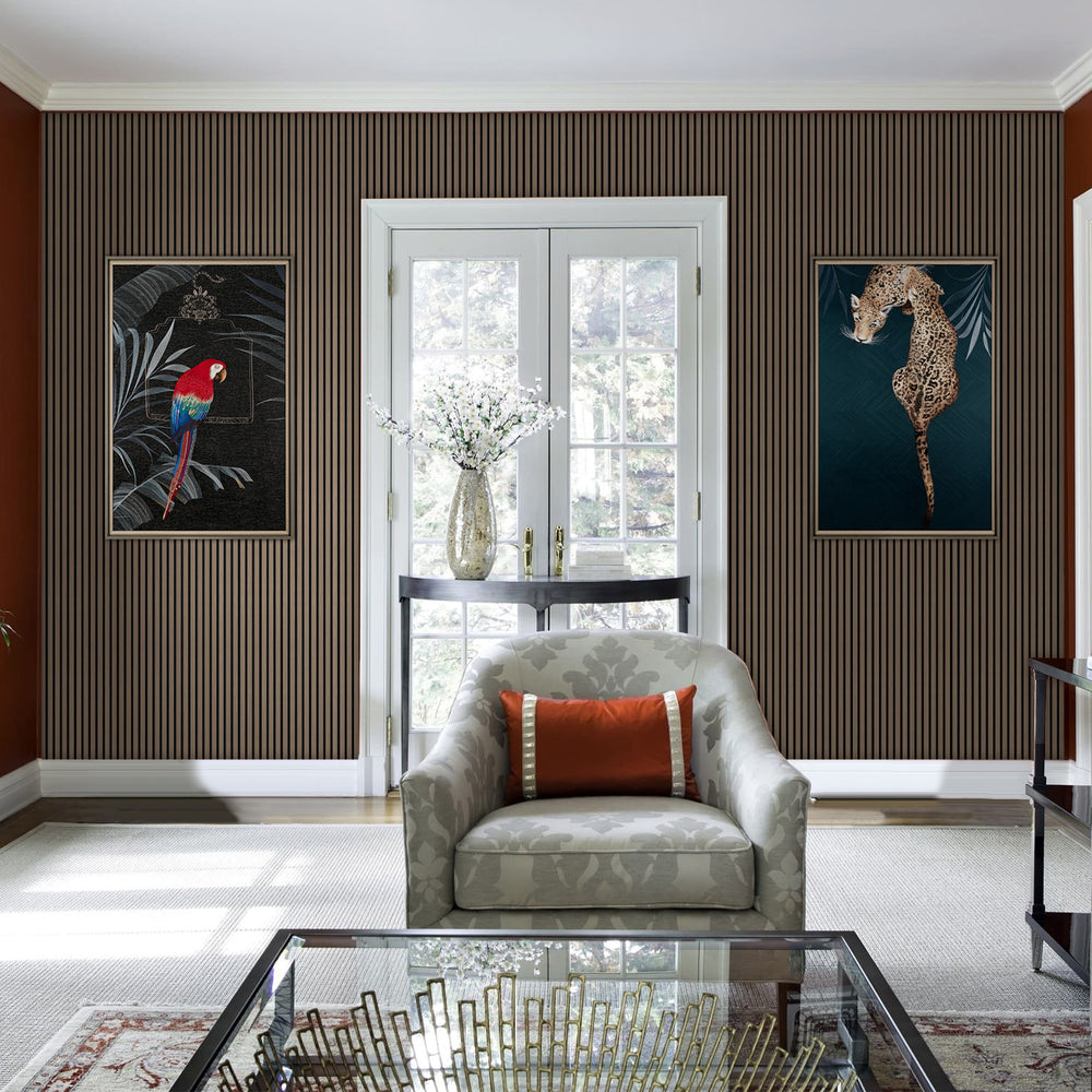 Cozy living room showcasing American natural walnut acoustic slat wood panels with black felt, featuring a gray armchair, orange throw pillow, glass coffee table, and large windows for natural light.