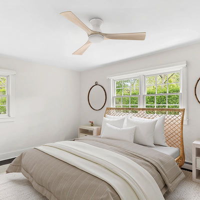 White flush mount 3-blade wood ceiling fan with LED light installed on the ceiling of a bright modern bedroom. #color_light-wood