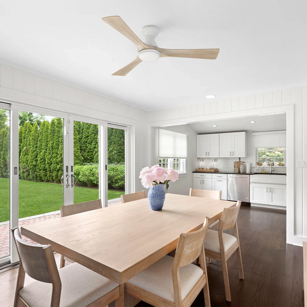 Antrim white flush mount 3-blade wood ceiling fan with LED light installed on the ceiling of a modern dining room and kitchen area. 