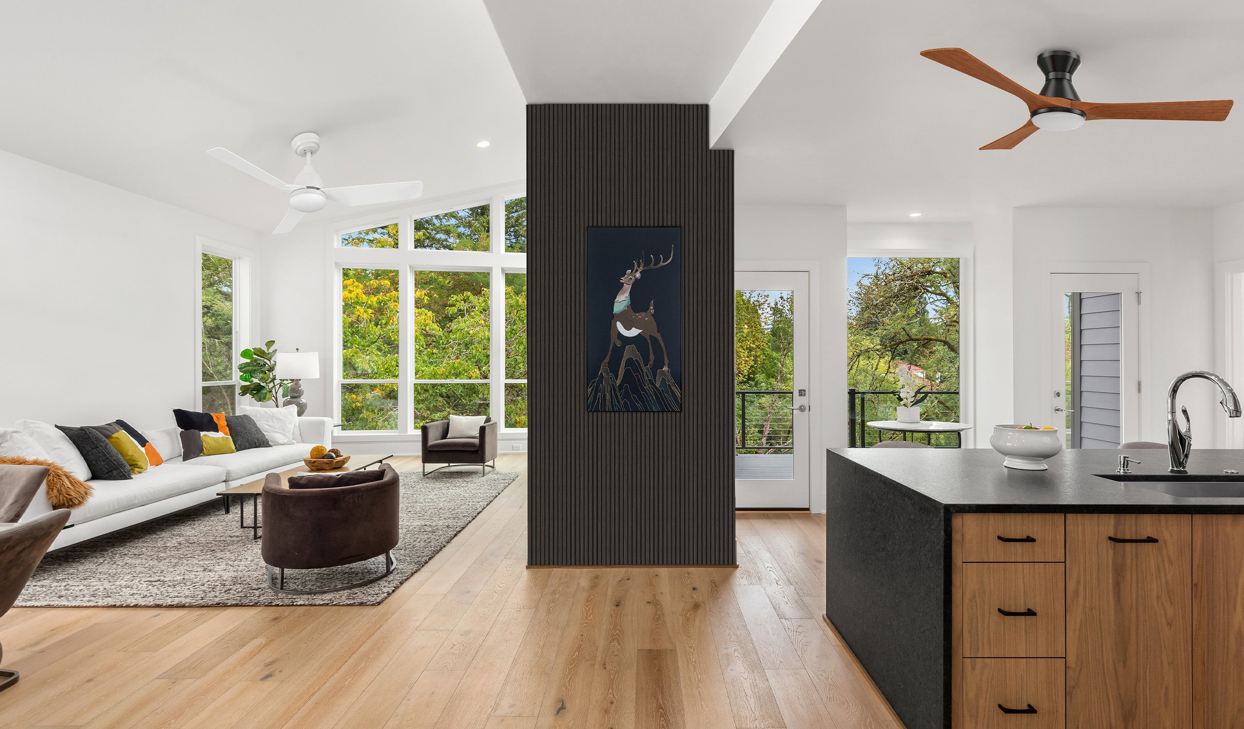 Modern open-plan room with Antrim and Silas smart ceiling fans, complemented by acoustic wall panels and artistic wall décor. Quiet, energy-efficient solutions for stylish interiors.