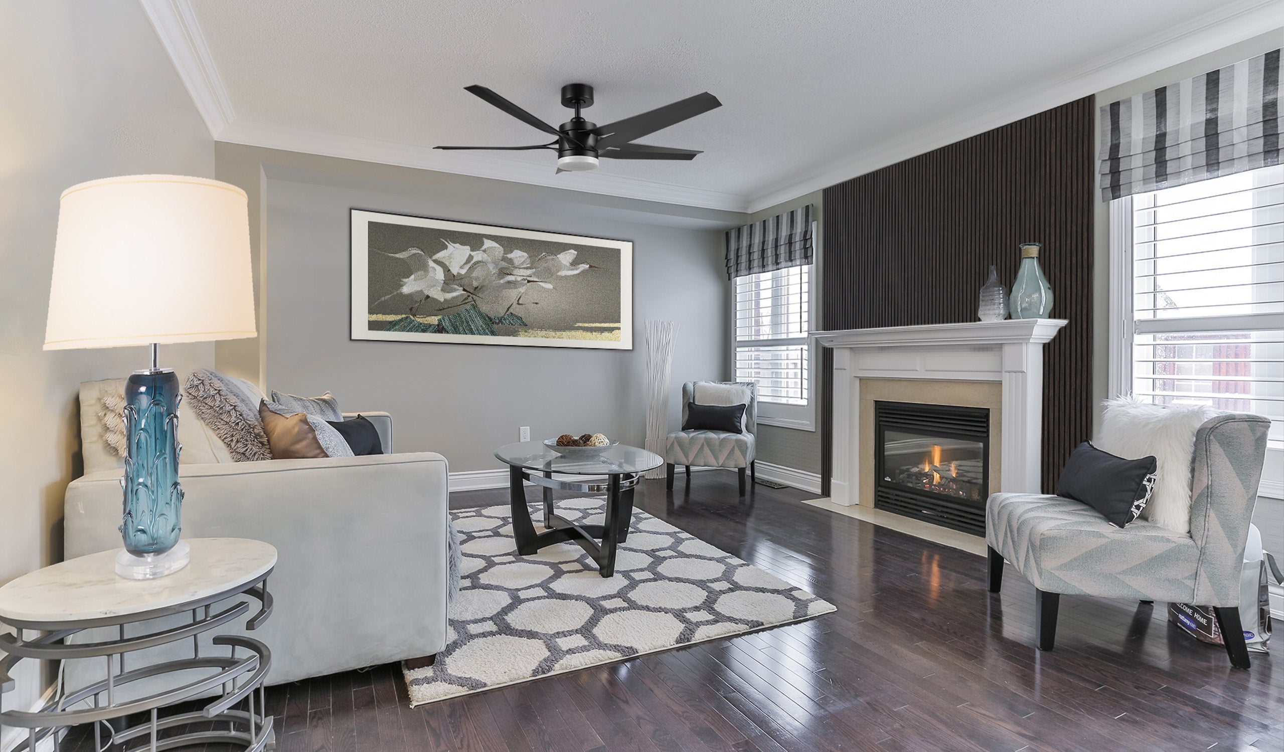Elegant living room with Araceli black ceiling fan with light, natural oak acoustic wall panels, stylish wall art, and a modern table lamp. Offers quiet operation and a luxurious atmosphere.
