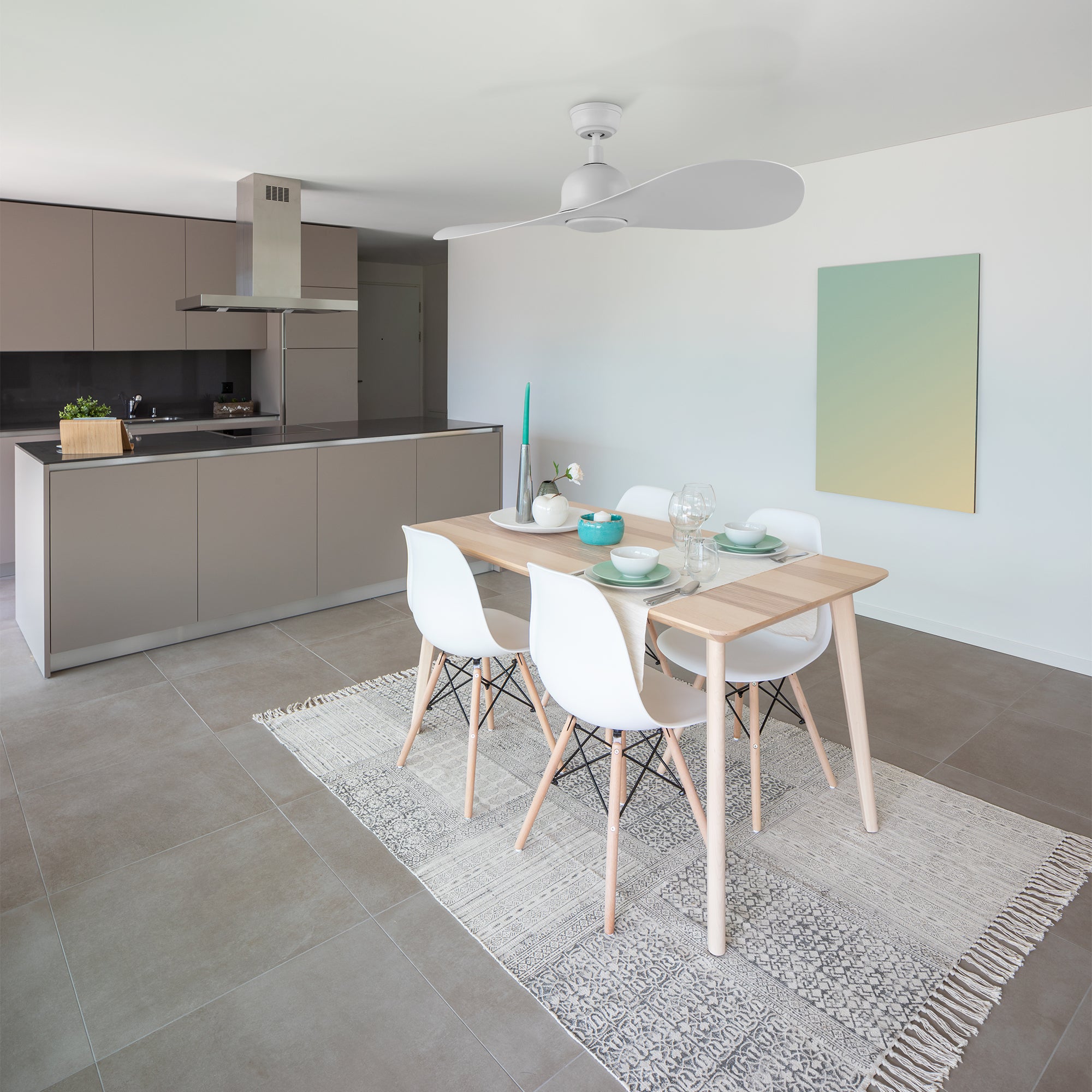 The 42-inch white smart ceiling fan is installed in the open plan dining room and kitchen, with light brown grey and solid wood furniture, making the entire interior space very elegant. 