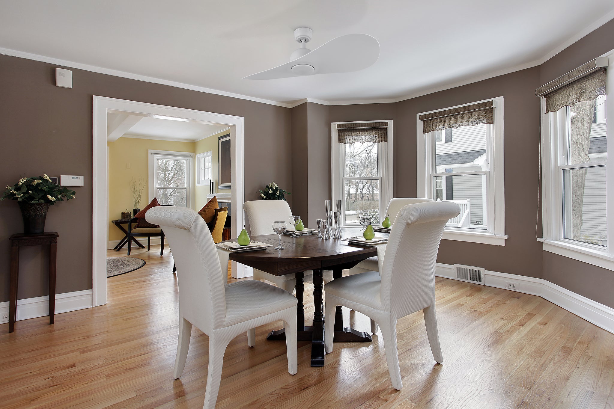 Azure white ceiling fan with LED light and two plastic blades, installed in a modern dining room.