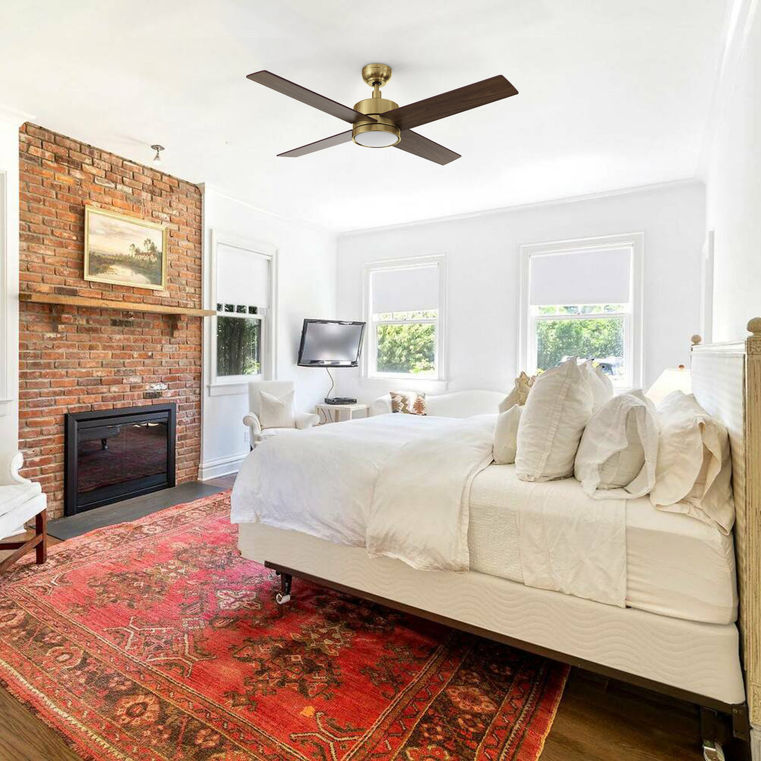 Scandinavian-style bedroom with the Carro Smafan Rossendale 52-inch ceiling fan in gold, mounted above a white bed and red rug. 