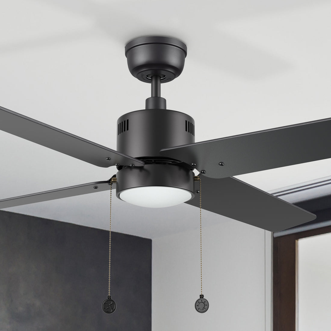 Carro Rowan 52 inch modern ceiling fan with LED light in a black finish, showcased in a spacious open living area.