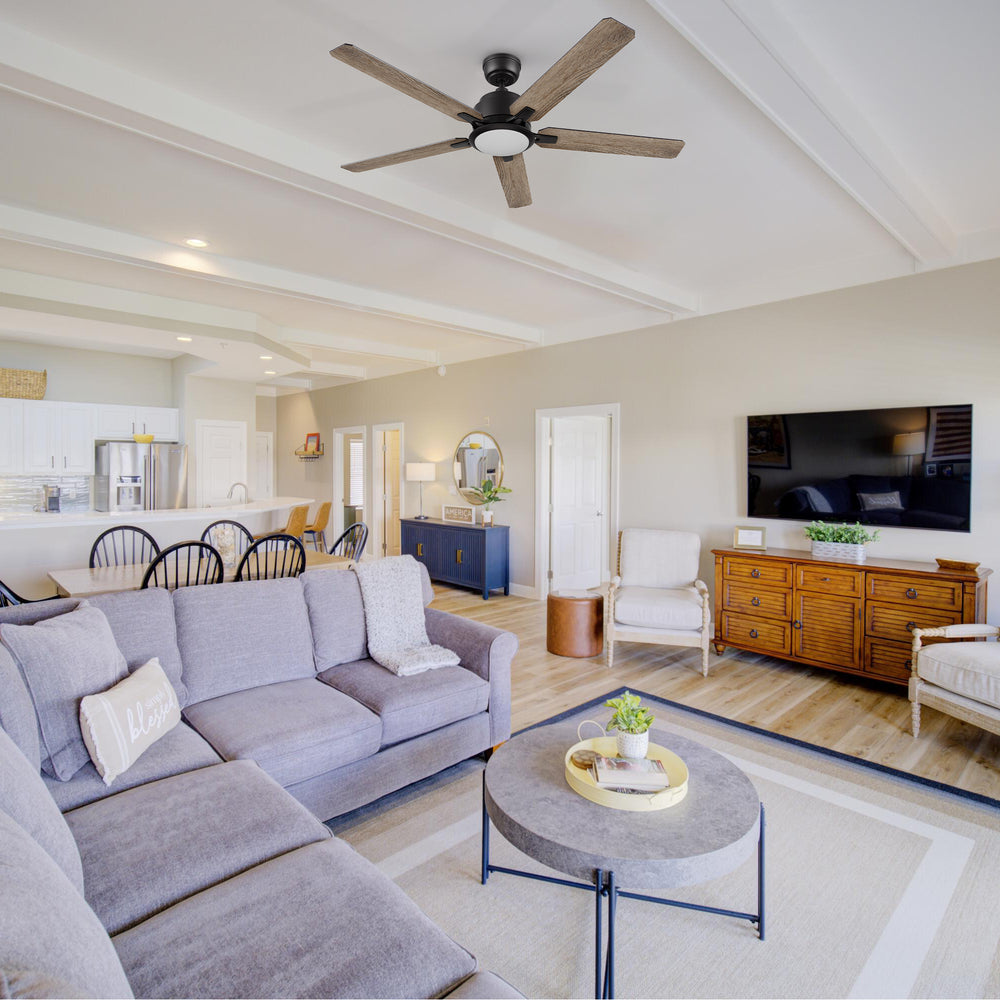 Carro Smafan Essex2 52-inch black smart ceiling fan with LED light installed in a bright modern living room with white sofa, wood coffee table, and TV console, highlighting versatile indoor use. 