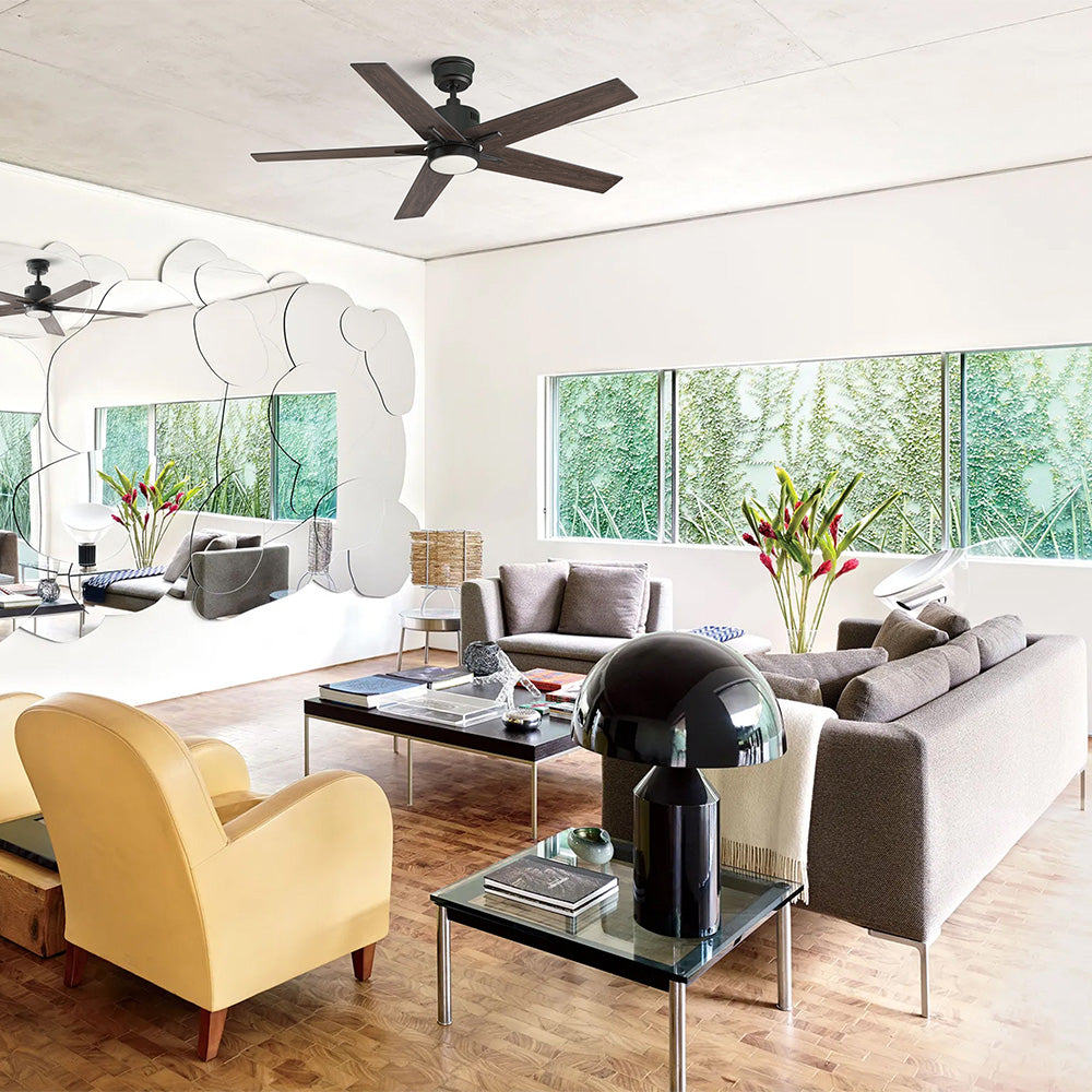 Smafan Coro modern black ceiling fan with dark wood blades and integrated light installed in a bright eclectic contemporary living room with unique cloud mirror and large picture windows. 