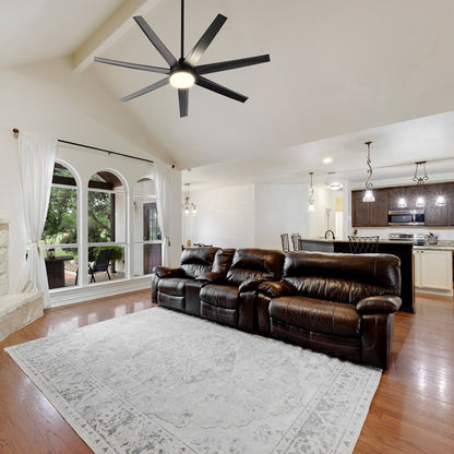 A spacious traditional living room featuring the Daventry 65-inch DC Motor Ceiling Fan with LED Light and Remote. The fan’s sleek black finish complements the warm décor, while its energy-efficient LED light kit and powerful airflow keep large indoor living spaces bright and comfortable. 