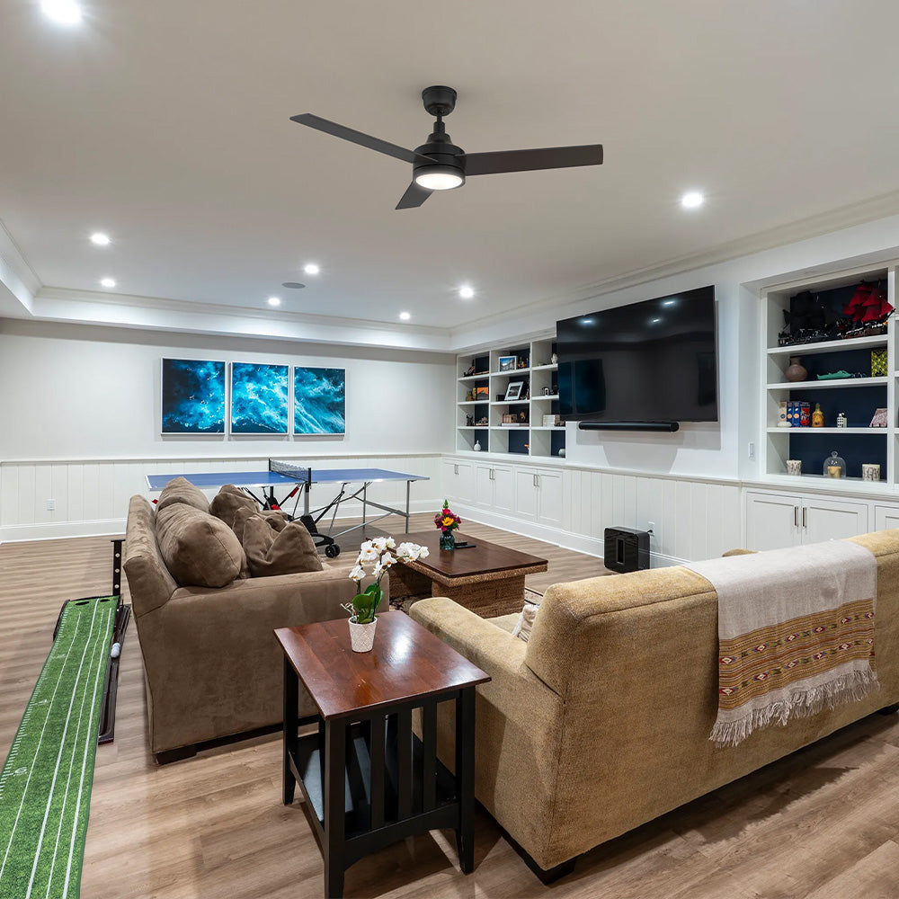Smafan Dulon 52 inch matte black ceiling fan with light installed in a spacious transitional finished basement featuring a ping-pong table and media lounge area. 