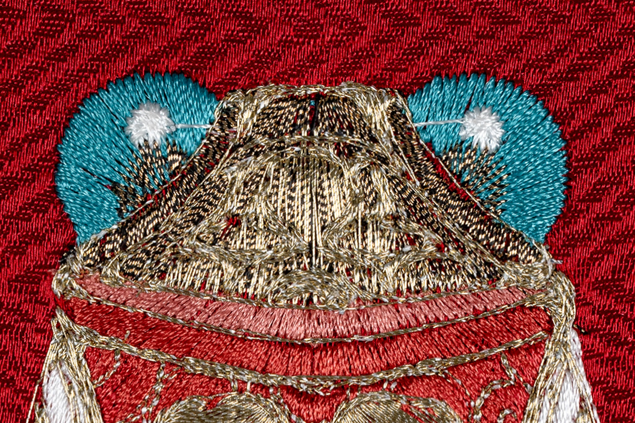 Blue eyes detail on cicada embroidery artwork.