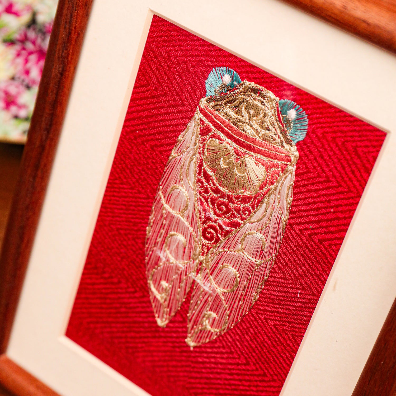 The golden threads details effect is highlighted in the close shot of Golden cicada seed embroidery artwork.