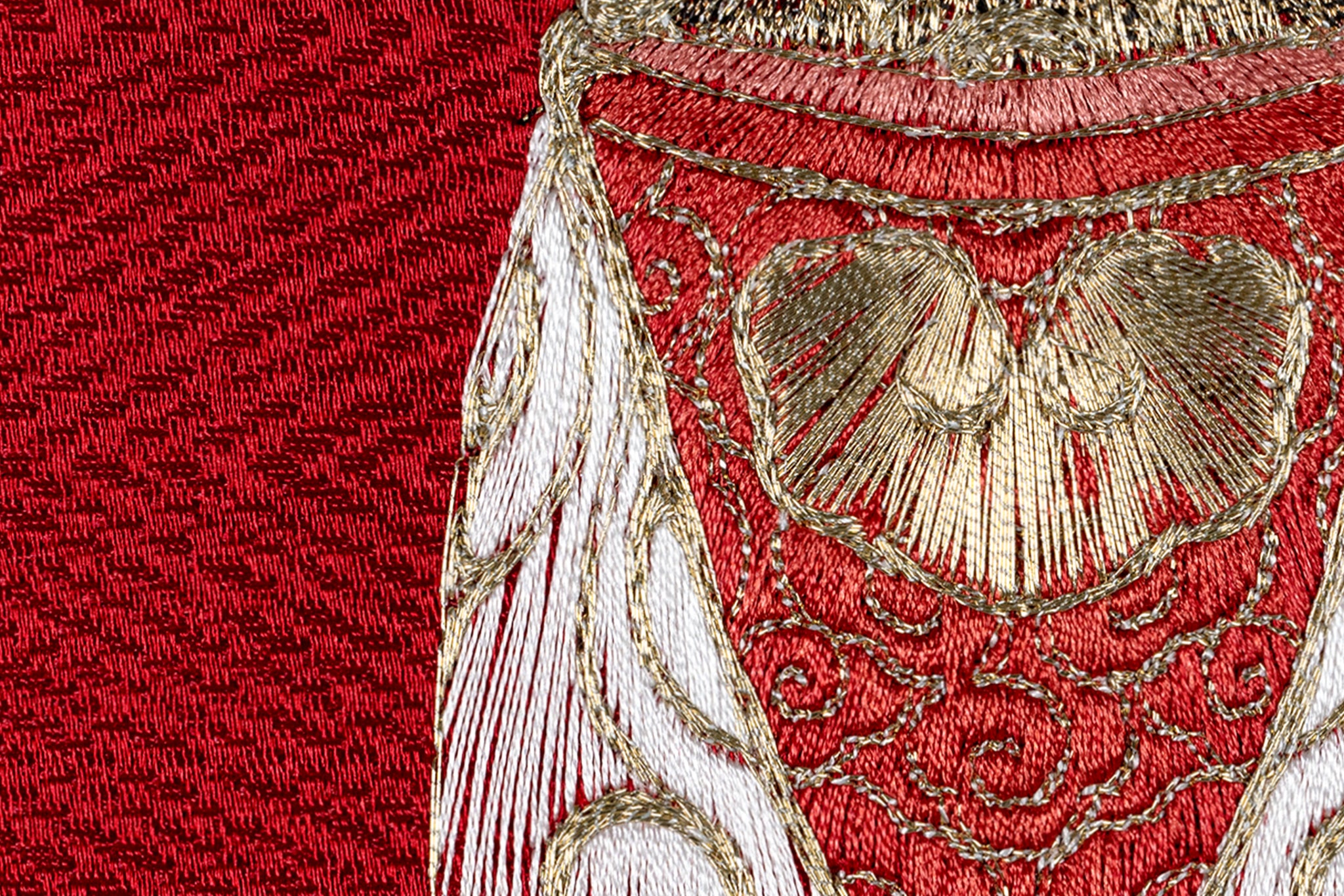 Red silk thread detail on cicada embroidery work.