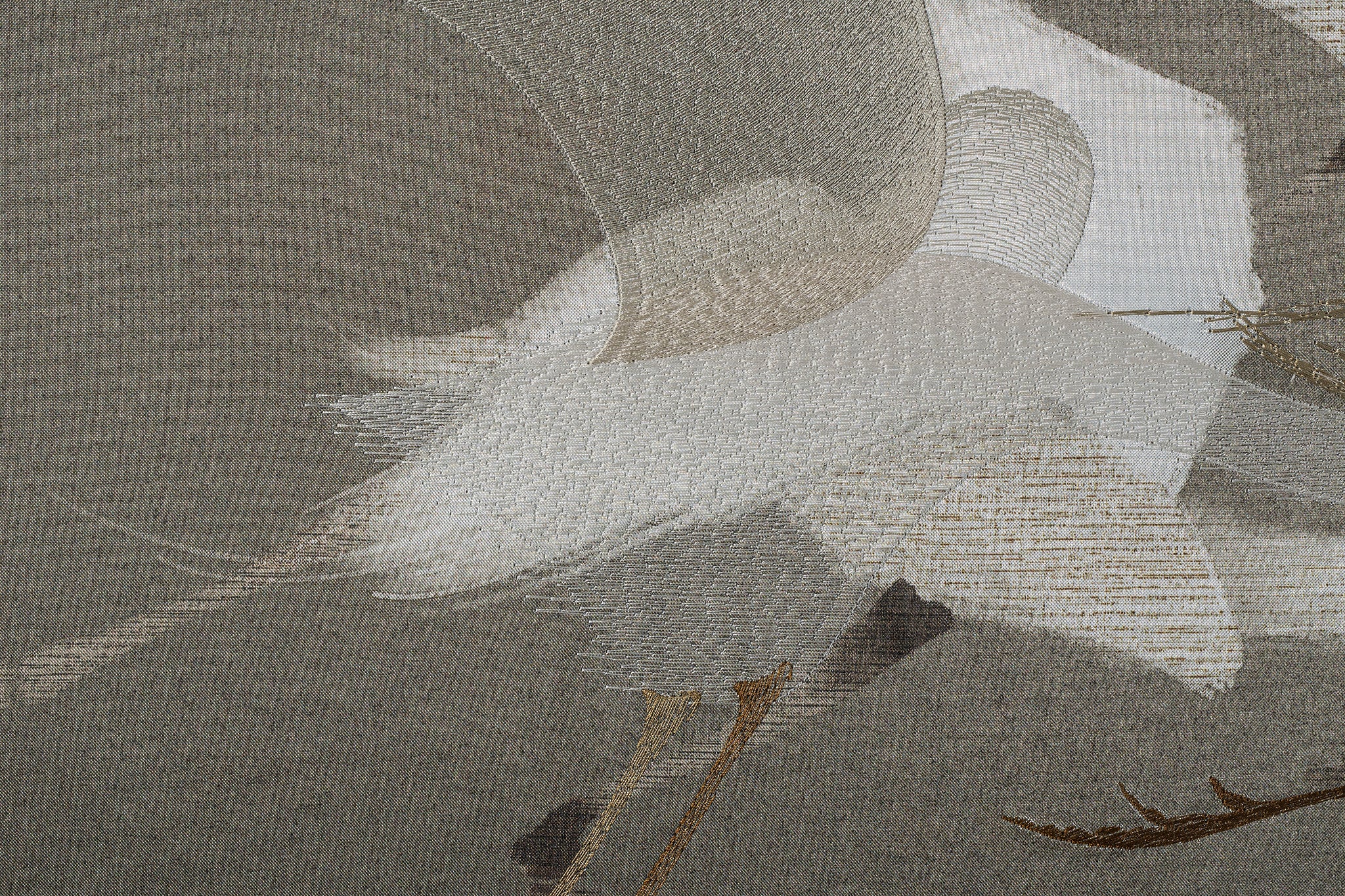 Close-up image showing the delicate embroidery details of an egret's feathers in the framed artwork featuring a flock of egrets.