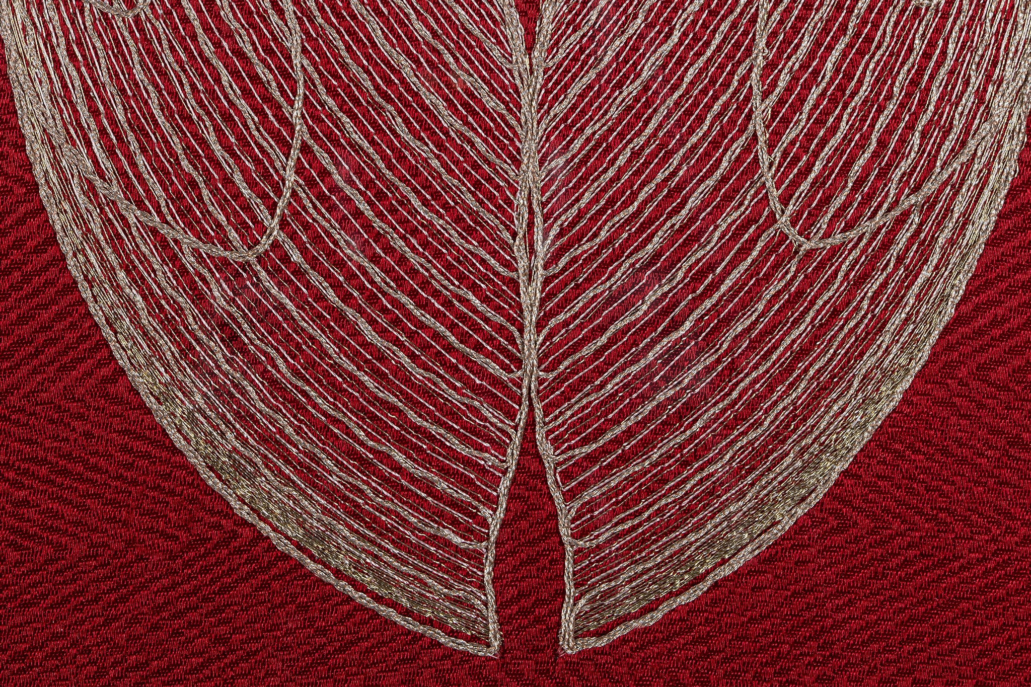 Close-up of the wing details of a framed embroidery artwork featuring a cicada design. The embroidery shows detailed patterns in white thread on a red background.