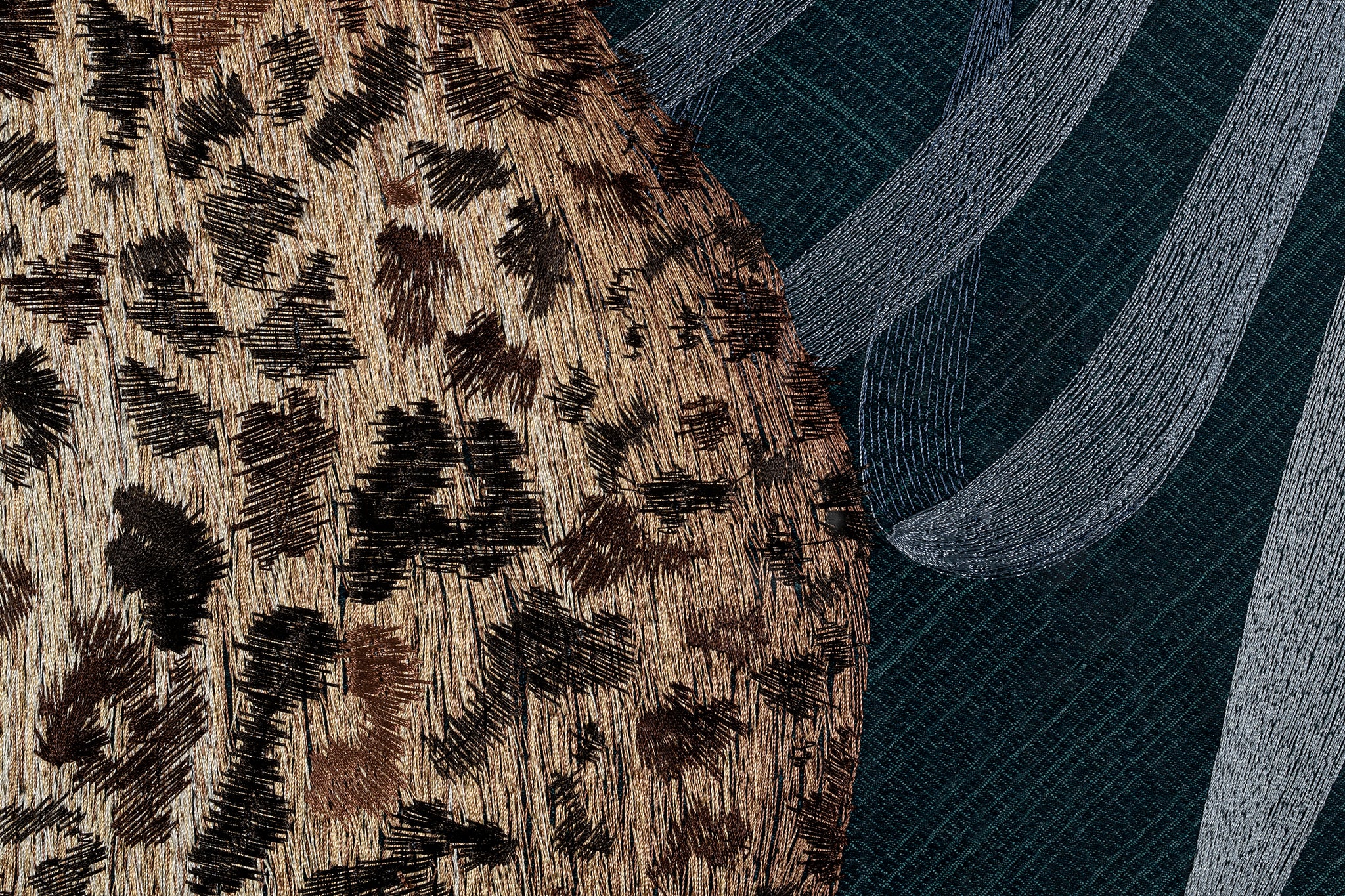 The fur and plant details of the leopard design in embroidery fine wall art.