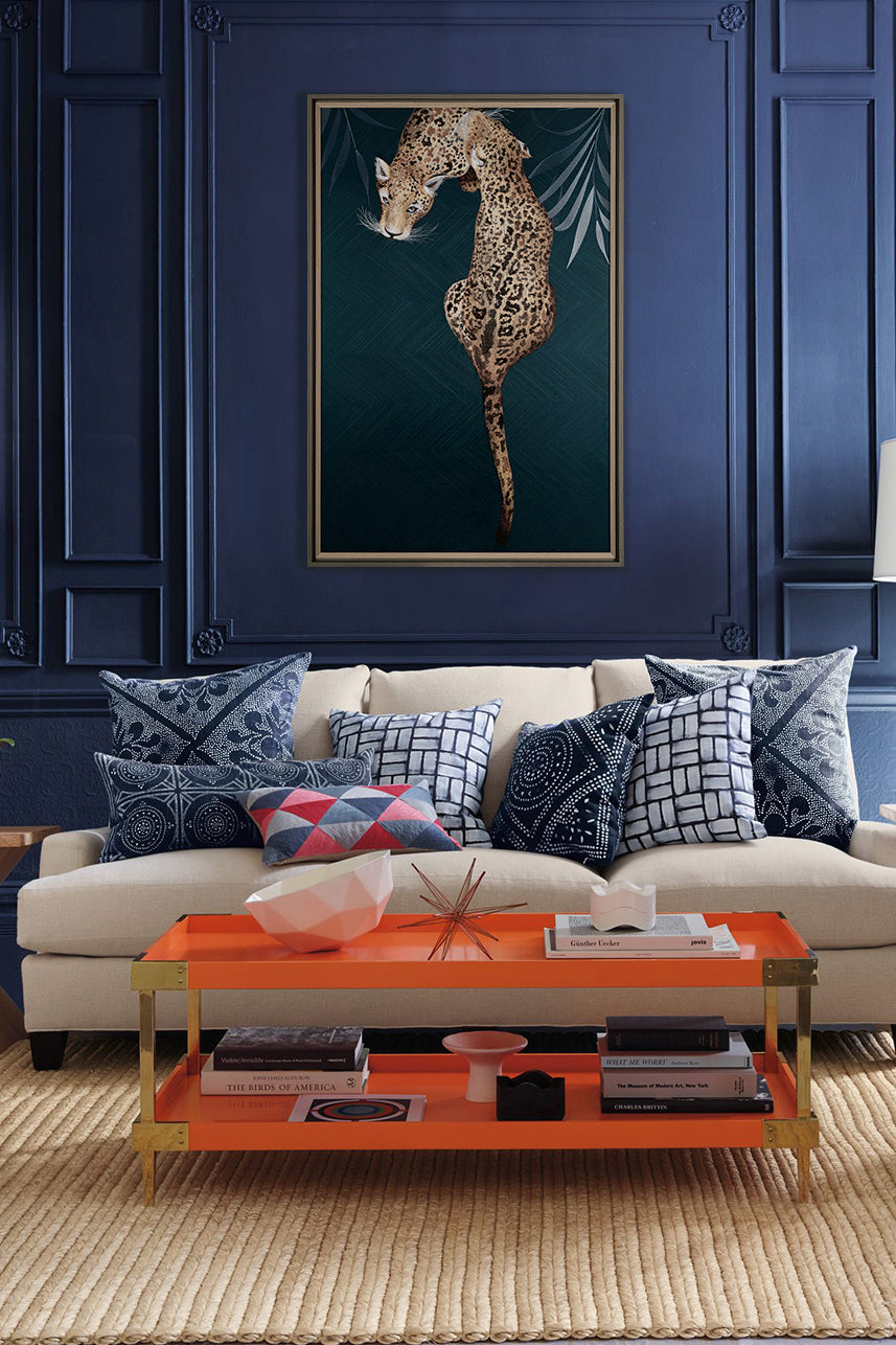 Framed Embroidery Fine Wall Art of Leopard Design hanging in a stylish living room with blue walls and a colorful, eclectic decor.