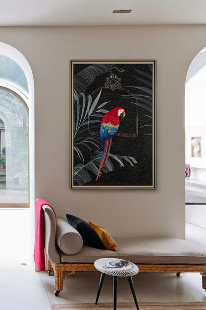 A bold, colorful parrot on the framed embroidery wall art in black is above an elegant bench with white cushions and rich red accents.