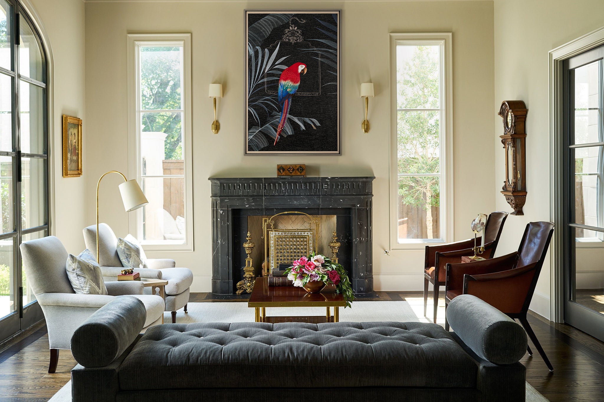 An framed embroidery art work embroidered with tropical parrots is hung on the wall above the fireplace in the living room. With bright flowers, the whole living room is very vibrant.