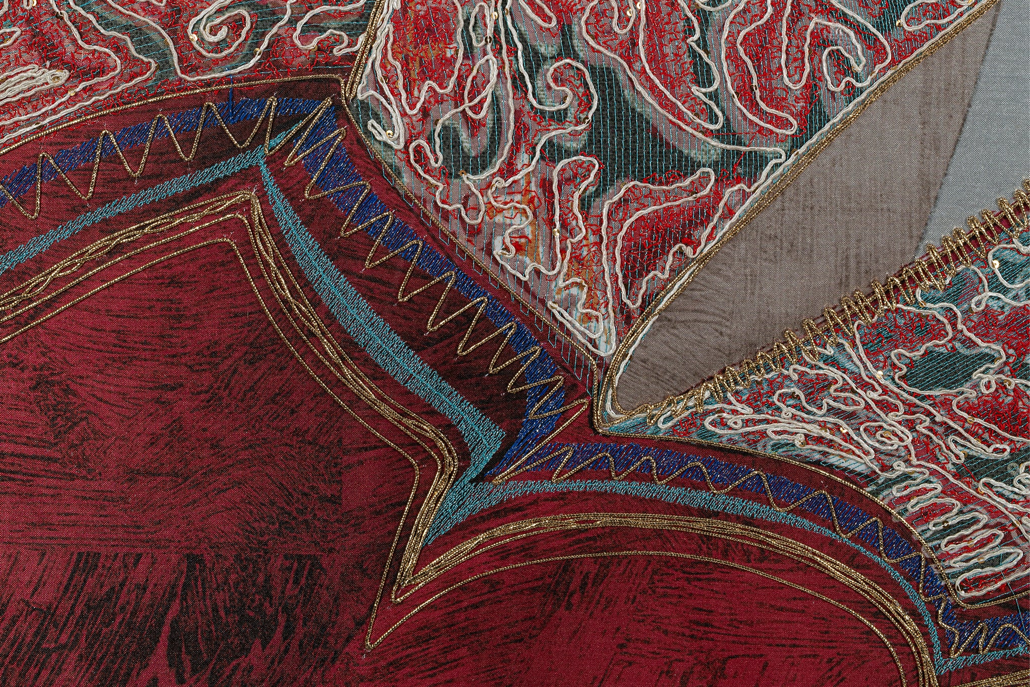 Through the blue, green, and white silk embroidery thread, presenting the artwork details of figure clothing.