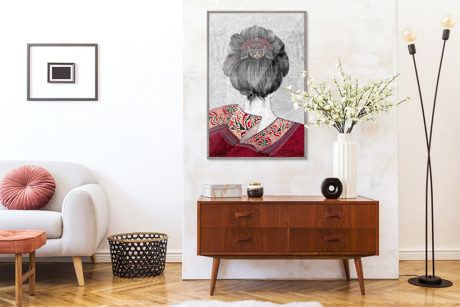 An framed embroidery art work embroidered with the back of a female figure is hung on the wall above the side table, with elegant milky white artificial cherry blossoms, which makes the whole living room very artistic.