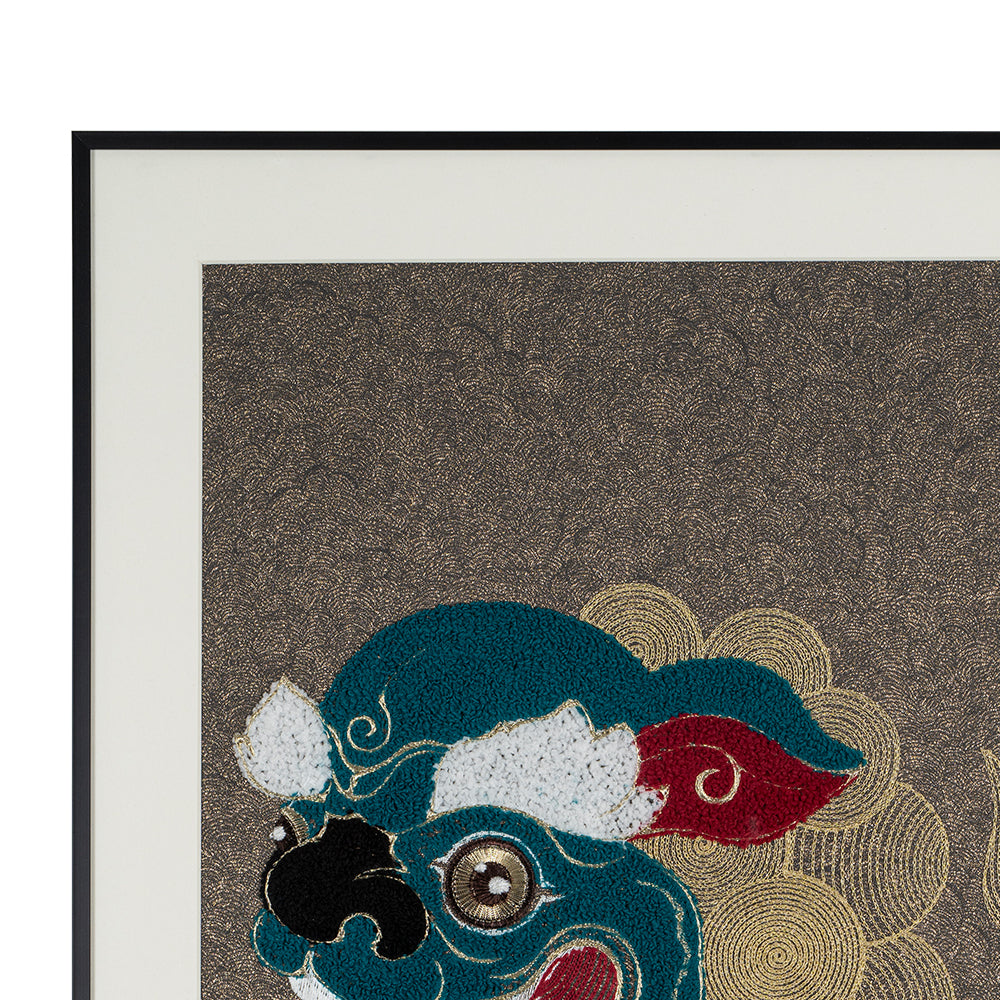 Detailed view of framed embroidery artwork highlighting the metal frame and the lions and ball design.